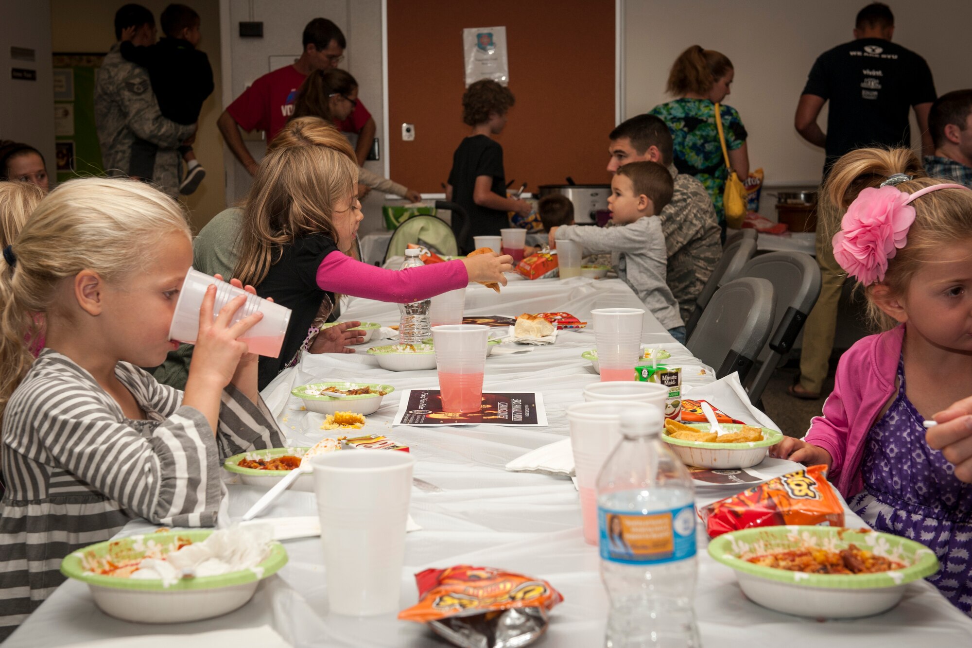 PETERSON AIR FORCE BASE, Colo. – Airmen and their families enjoy chili and other snacks from the chili cook-off held Oct. 1 at the Peterson AFB Chapel. The competition consisted of 10 different types of chilis with chapel spouses making up the judging panel to decide which one was best. The winner was a white chicken chili, which was eaten the quickest and created by Haila Hill, wife of Maj. George Hill, U.S. Northern Command. (U.S. Air Force photo by Senior Airman Rose Gudex)