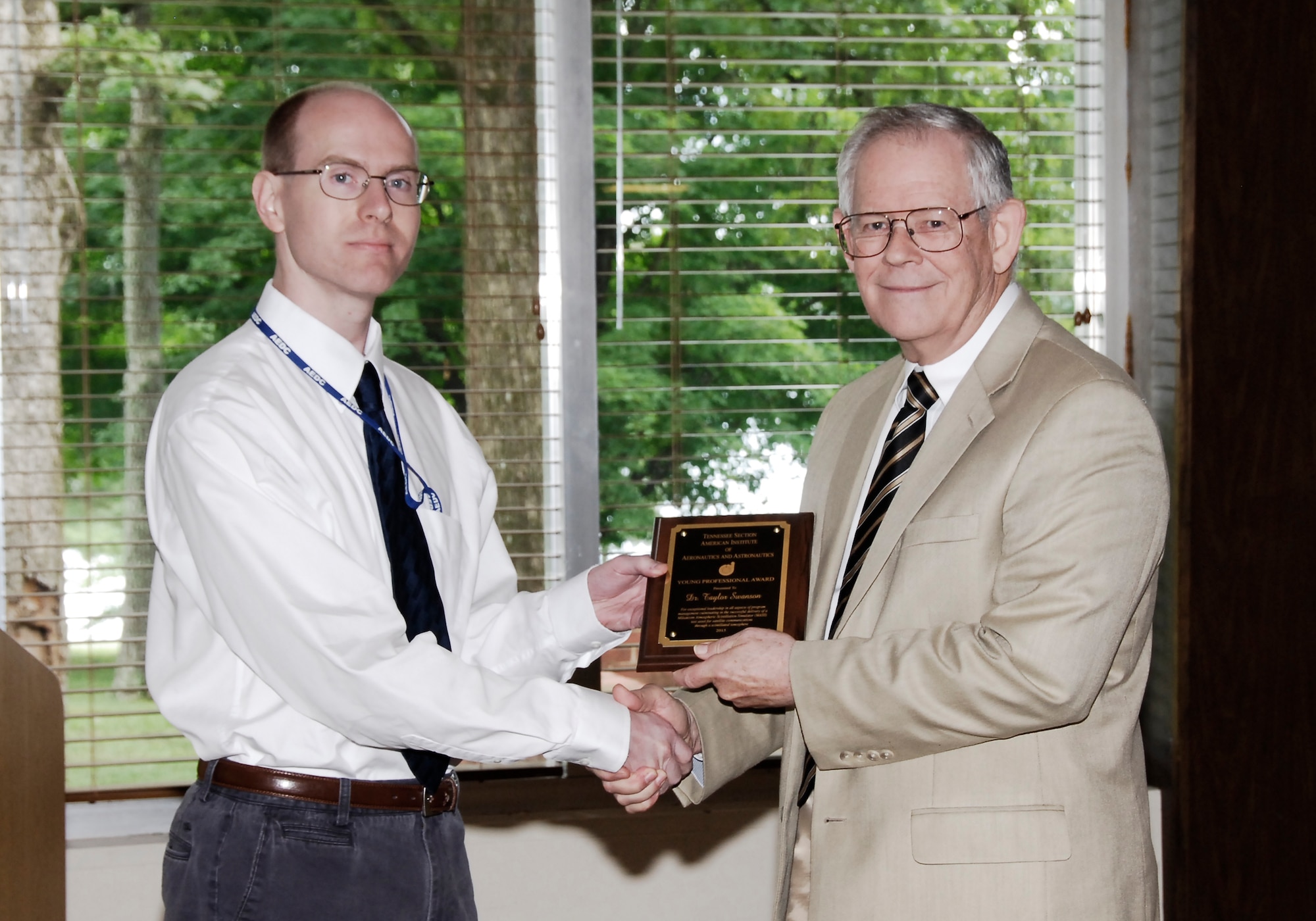 AEDC employee Taylor Swanson (left) receives an AIAA Tennessee Section Young Professional Award for his development of the Milsatcom Atmospheric Scintillation Simulator project from nominator and AIAA member Dr. Bill Baker.