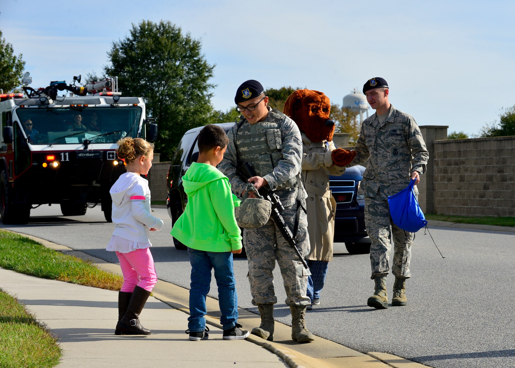 Airmen from the 436th Security Forces Squadron hand out candy to children during the Fire Prevention Week parade Oct. 10, 2015, in base housing at Dover Air Force Base, Del. After the parade, the 436th Civil Engineer Fire Department hosted an open house event and Military Appreciation Day picnic. (U.S. Air Force photo/Senior Airman William Johnson)