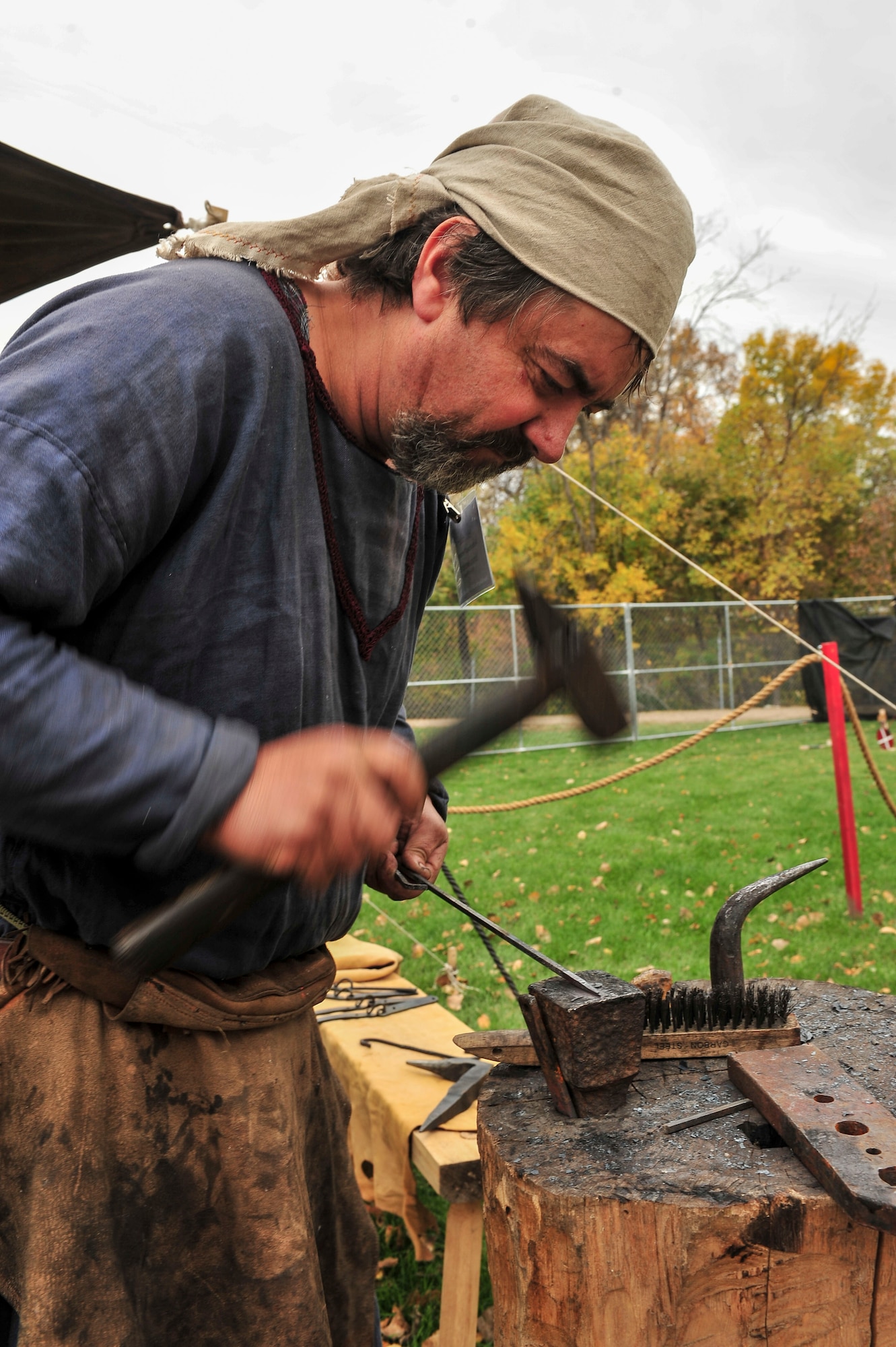 Douglas Swenson, traditional blacksmith, works his forge during Norsk Hostfest Military Appreciation Day in Minot N.D., Oct. 3, 2015. Swenson creates custom iron work as the owner of the Goose Prairie Forge and put his training in traditional blacksmithing on display during the festival. (U.S. Air Force photo/Senior Airman Stephanie Morris)