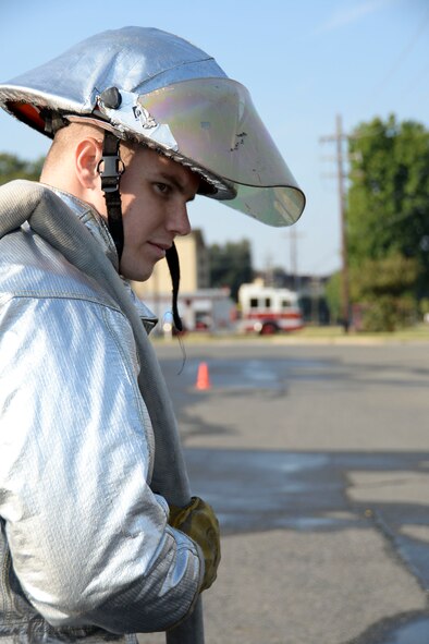 An Airman waits in anticipation to perform a hose pull during a fire muster competition for fire prevention week at Barksdale Air Force Base, La., Oct. 8, 2015. The fire muster was one of several events that the 2nd Civil Engineer Squadron fire department hosted to raise awareness during fire prevention week.  (U.S. Air Force photo/Senior Airman Amanda Morris)