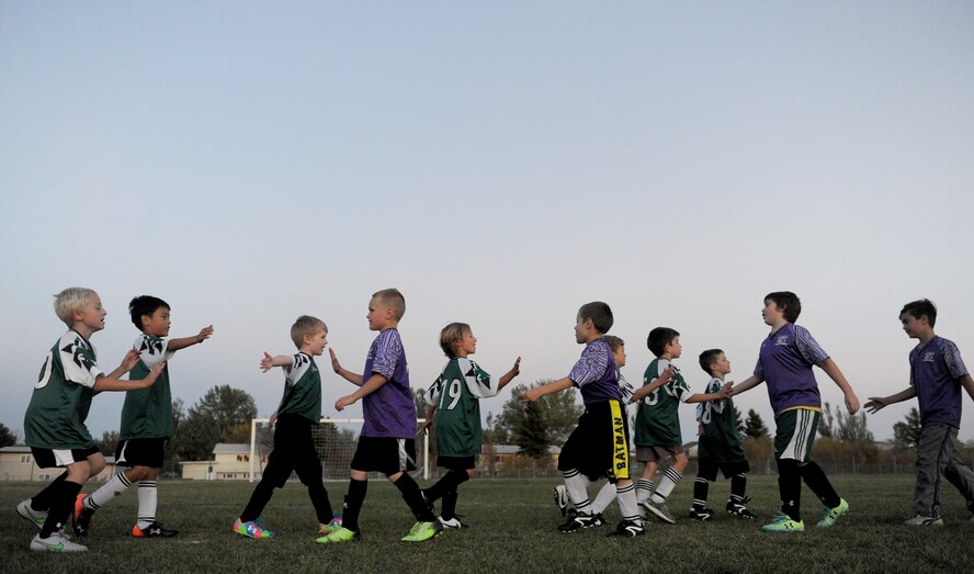 Children from the youth center high five each other at the end of their soccer match at Minot Air Force Base, N.D. Oct. 6, 2015. The children were playing their final soccer game of the season which is part of many programs and activities the youth center provides. (U.S. Air Force photo by Staff Sgt. Chad Trujillo)