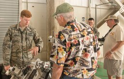 Senior Airman Joshua Sanders, 628th Civil Engineering Squadron explosive ordinance disposal apprentice, explains  EOD equipment to Joe Burkhart, Vietnam War veteran, in a hangar at Joint Base Charleston – Air Base, S.C., on Oct. 10, 2015. Burkhart and the other Vietnam War veterans were visiting JB Charleston for a base tour. (U.S. Air Force photo/Airman 1st Class Thomas T. Charlton)