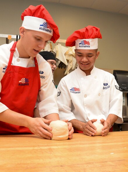 Airman Joseph Szafranski and Airman 1st Class Ruel Abastas, 90th Force Support Squadron missile chefs from F.E. Warren Air Force Base, Wyo., measure rolls of dough before baking at Bossier Parish Community College in Bossier City, La., Oct. 6, 2015. Airmen from various Air Force Global Strike Command bases assisted the culinary students in preparing a buffet-style meal for 800 people. The Airmen had the opportunity to collaborate with the culinary students before competing in the Global Strike Challenge Chef Competition, allowing them to learn new tips and tricks and pass along their own. (U.S. Air Force photo/Senior Airman Amanda Morris)
