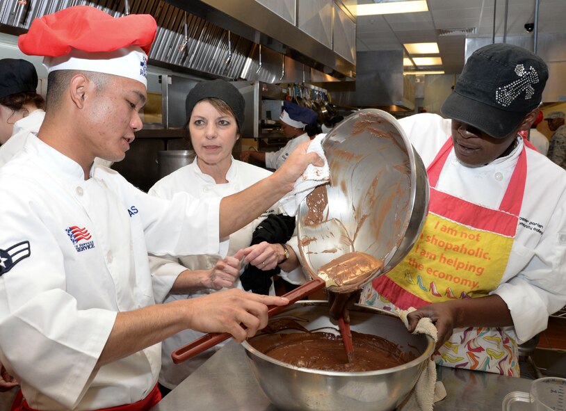 Airman 1st Class Ruel Abastas, 90th Force Support Squadron missile chef from F.E. Warren Air Force Base, Wyo., and culinary students from Bossier Parish Community College, pour melted chocolate at BPCC in Bossier City, La., Oct. 6, 2015. Airmen from various bases in Air Force Global Strike Command assisted the culinary students in preparing a buffet-style meal for 800 people. While at BPCC, the Airmen learned tips and tricks before competing in the Global Strike Challenge Chef Competition. (U.S. Air Force photo/Senior Airman Amanda Morris)
