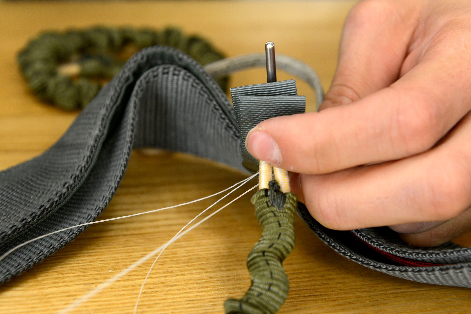 A U.S. Air Force Airman rigs the risers of the ACES II parachute system at Shaw Air Force Base, S.C., Oct. 8, 2015. The risers are the lowest part of the entire assembly and connect the parachute to the harness worn by the pilot during flight.  The elastic cord assembly keeps the risers secure during flight. (U.S. Air Force photo by Airman 1st Class Christopher Maldonado/Released) 