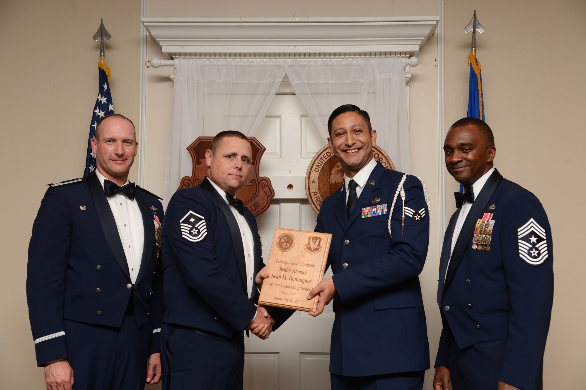 U.S. Air Force Senior Airman Sean Dominguez, 31st Intelligence Squadron, receives a distinguished graduate award for the Senior Master Sgt. David B. Reid Airman Leadership School Class 15-7 from Master Sgt. Ryan Glosson, 372nd Recruiting Squadron first sergeant, at Shaw Air Force Base, S.C., Oct. 9, 2015. The distinguished graduate awards are given to the top 10 percent of the class for total point accumulation. (U.S. Air Force photo by Senior Airman Jonathan Bass/Released)