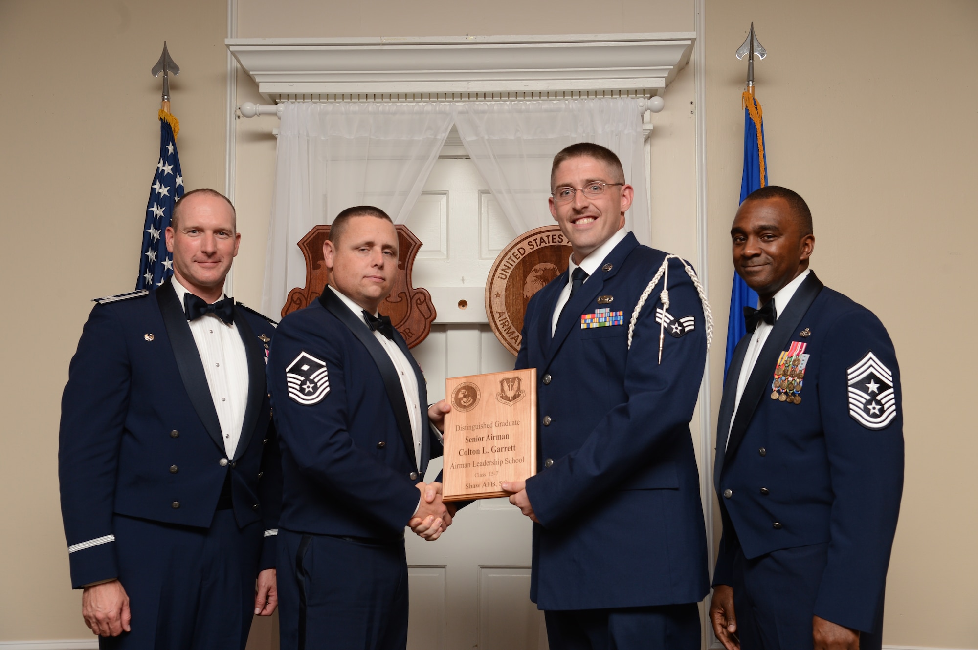 U.S. Air Force Senior Airman Colton Garrett, 51st Intelligence Squadron, receives a distinguished graduate award for the Senior Master Sgt. David B. Reid Airman Leadership School Class 15-7 from Master Sgt. Ryan Glosson, 372nd Recruiting Squadron first sergeant, at Shaw Air Force Base, S.C., Oct. 9, 2015. The distinguished graduate awards are given to the top 10 percent of the class for total point accumulation. (U.S. Air Force photo by Senior Airman Jonathan Bass/Released)