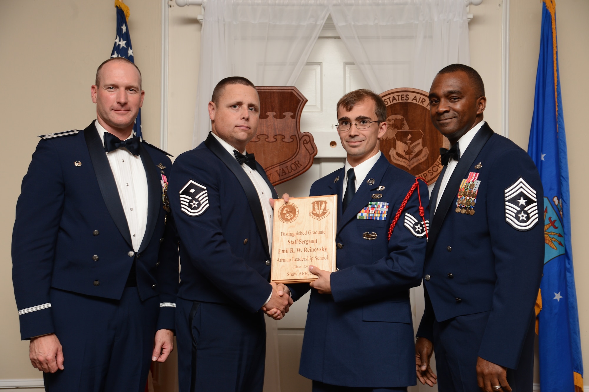 U.S. Air Force Staff Sgt. Emil Reinovsky, 15th Air Support Operations Squadron receives a distinguished graduate award for the Senior Master Sgt. David B. Reid Airman Leadership School Class 15-7 from Master Sgt. Ryan Glosson, 372nd Recruiting Squadron first sergeant, at Shaw Air Force Base, S.C., Oct. 9, 2015. The distinguished graduate awards are given to the top 10 percent of the class for total point accumulation. (U.S. Air Force photo by Senior Airman Jonathan Bass/Released)