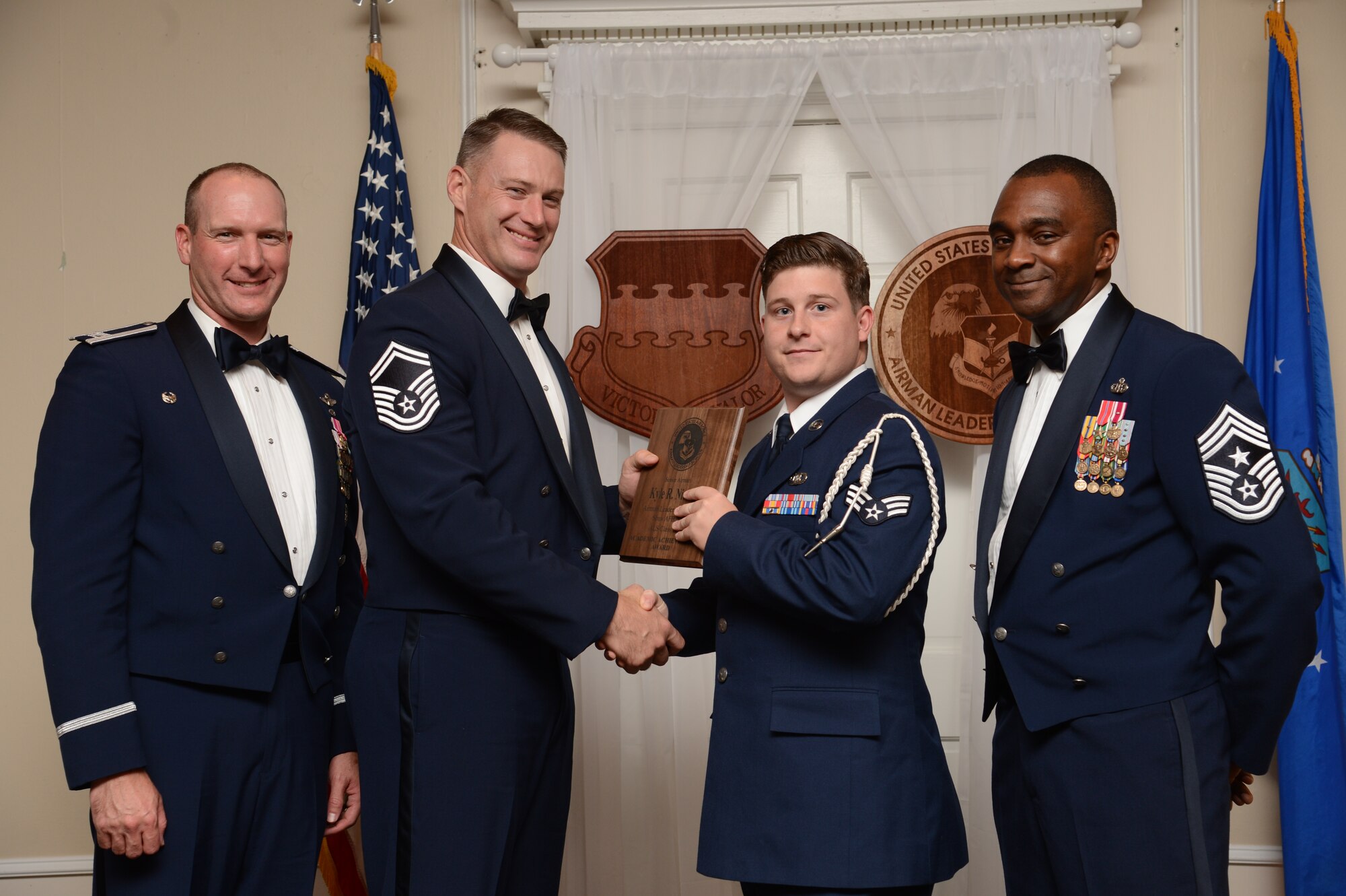 U.S. Air Force Senior Airman Kyle Nielson, 609th Air Operations Center, Detachment 1, receives the Senior Master Sgt. David B. Reid Airman Leadership School Academic Achievement award from Senior Master Sgt. Jacob Peeterse, 20th Component Maintenance Squadron test measurements diagnostics equipment flight chief, during the ALS Class 15-7 graduation at Shaw Air Force Base, S.C., Oct. 9, 2015. This award is given to the student with the highest point total. (U.S. Air Force photo by Senior Airman Jonathan Bass/Released)