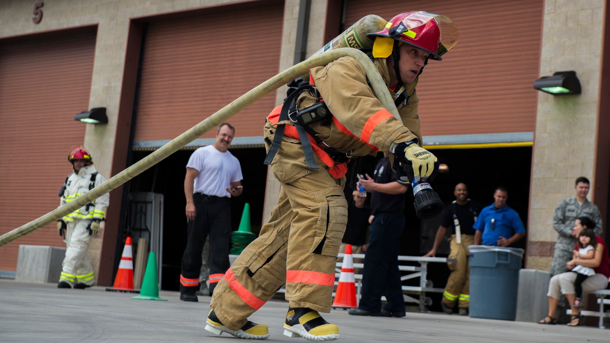 Master Sgt. William Wallick, the 49th Civil Engineer Squadron first sergeant, drags a fire hose across the finish line during the firefighter muster challenge at Holloman Air Force Base, N.M., Oct. 9, 2015. The firefighter muster challenge is designed to show teams what it takes to endure the physical challenges that fire fighters face on a regular basis. (U.S. Air Force photo by Airman 1st Class Emily A. Kenney/Released)