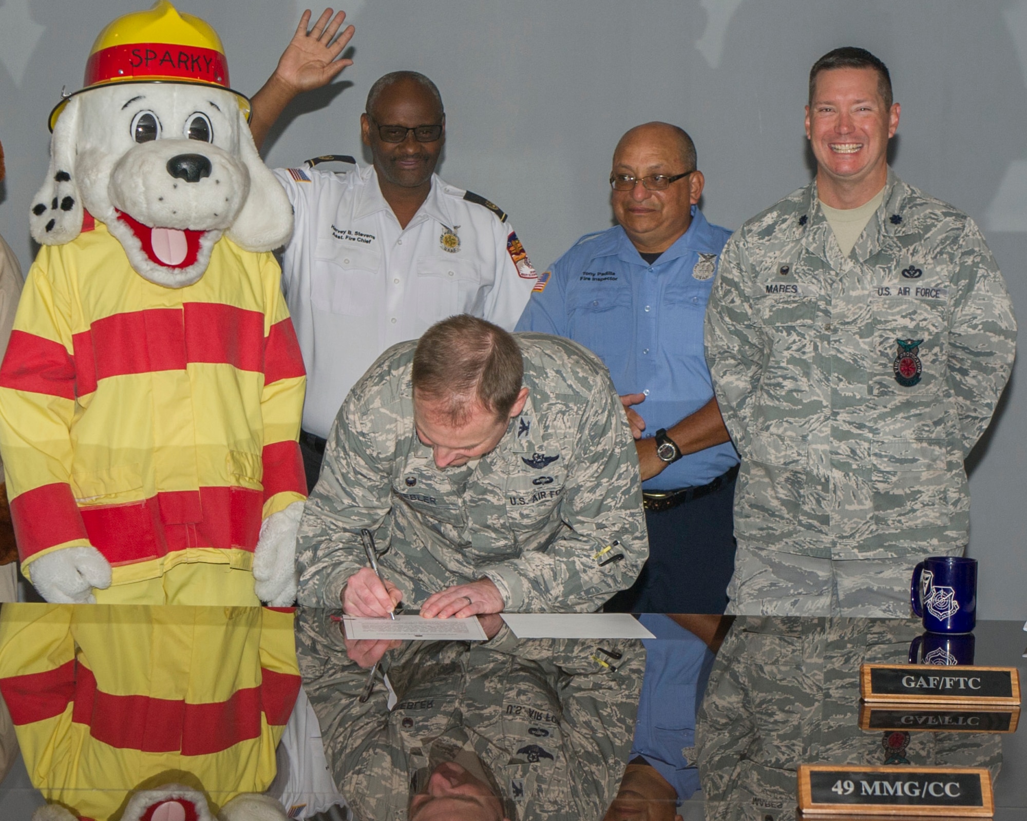 Colonel Robert Kiebler, the 49th Wing Commander, signs the Fire Prevention Week proclamation at Holloman Air Force Base, N.M., Oct. 7, 2015. Fire Prevention week happens annually to commemorate the great Chicago Fire of 1871. Firefighters from around Holloman go to schools on base and educate children about the importance of fire safety. (U.S. Air Force photo by Airman 1st Class Emily A. Kenney/ Released)