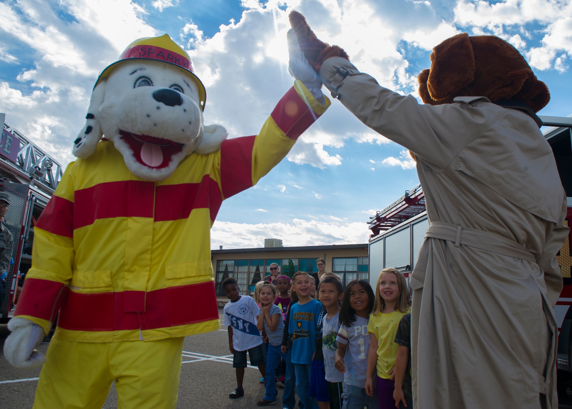 Sparky the Fire Dog high-fives McGruff the Crime Dog during a visit to Holloman Elementary School, Oct. 6, 2015. Oct. 4 marked the beginning of Fire Prevention Week, which is observed annually to commemorate the great Chicago Fire of 1871. (U.S. Air Force photo by Airman 1st Class Emily A. Kenney/ Released) 