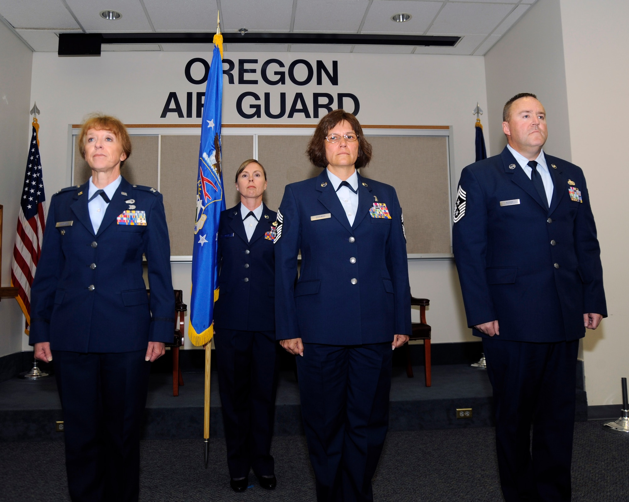 Col. Donna Prigmore, 142nd Fighter Wing Vice Commander, left, outgoing Command Chief Master Sgt. Julie Eddings, center, and incoming 142nd Command Chief Master Sgt. Chris Roper, right, stand at attention during the opening of their Change of Authority ceremony, Sept. 13, 2015, Portland Air National Guard Base, Ore. (U.S. Air National Guard photo by Tech. Sgt. Aaron Perkins, 142nd Fighter Wing Public Affairs/released)