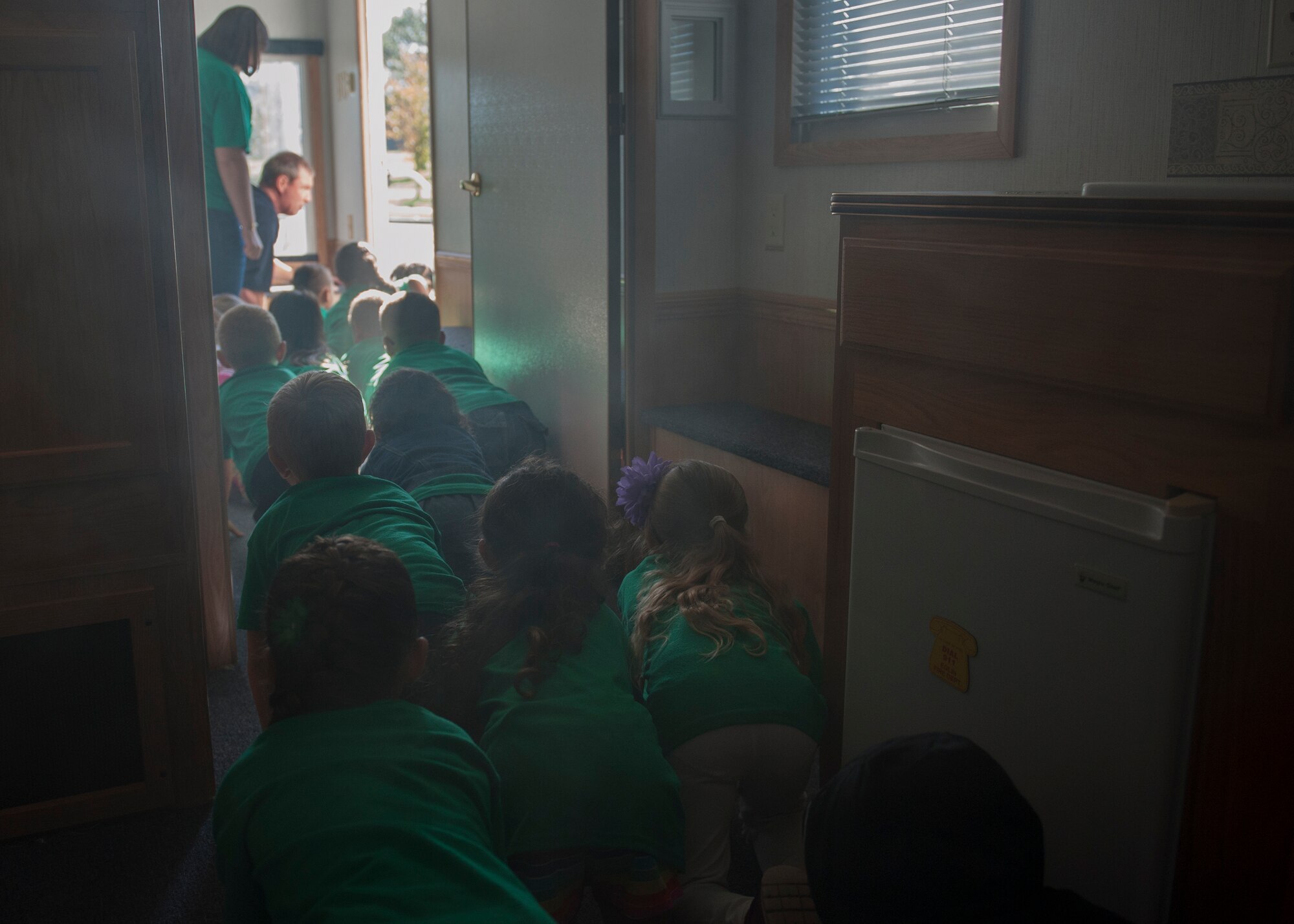 Children from the Eglin Elementary School exit the 96th Civil Engineer Squadron’s Fire Safety House Oct. 6 during Fire Prevention Week at Eglin Air Force Base, Fla. Eglin Fire Department personnel provided basic fire safety education that included the importance of knowing your address, how to dial 911 during an emergency as well as cooking and electrical safety. The children also practiced how to stay low and escape a smoke filled house. (U.S. Air Force photo/Ilka Cole) 