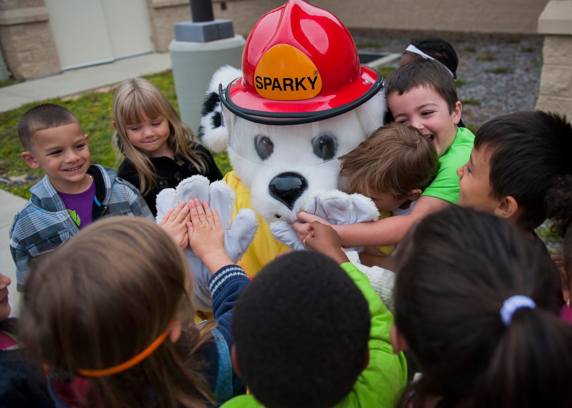 Children from the Child Development Center hug and greet Sparky the Fire Dog Oct. 6 during Fire Prevention Week at Eglin Air Force Base, Fla. Eglin Fire Department personnel provided basic fire safety education that included the importance of knowing your address, how to dial 911 during an emergency and a demonstration of stop, drop and roll. The children also practiced how to stay low and escape a smoke filled house. (U.S. Air Force photo/Ilka Cole) 