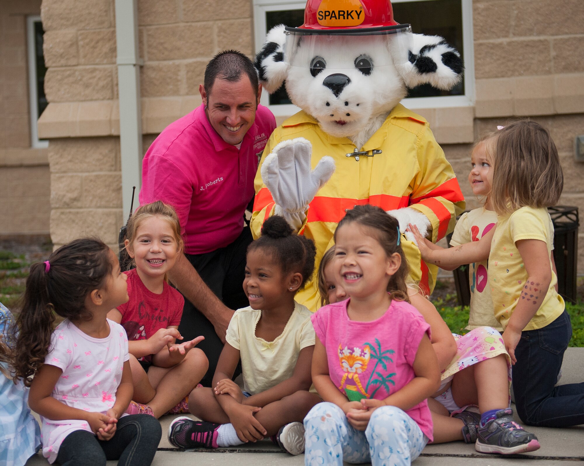 Jeffrey Roberts and Sparky the Fire Dog, visit children from the Child Development Center Oct. 6 during Fire Prevention Week at Eglin Air Force Base, Fla. Eglin Fire Department personnel provided basic fire safety education that included the importance of knowing your address, how to dial 911 during an emergency and a demonstration of stop, drop and roll. The children also practiced how to stay low and escape a smoke filled house. (U.S. Air Force photo/Ilka Cole) 