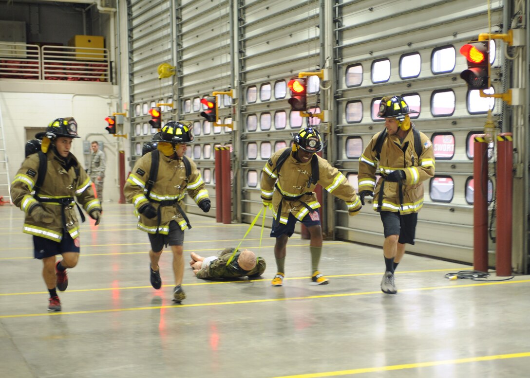 Airmen participate in a dummy drag obstacle as a part of the Firefighter Challenge at Ellsworth Air Force Base, S.D., Oct. 2, 2015. The rescue dummy weighed approximately 200 pounds and simulated rescuing an unconscious smoke inhalation victim. (U.S. Air Force photo by Airman Sadie Colbert/Released)