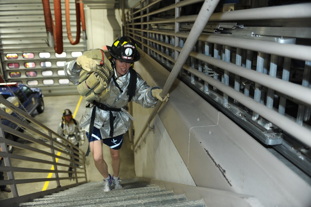 Lt. Col. Jennifer Phelps, 28th Civil Engineer Squadron commander, participates in the annual Firefighter Challenge by performing one of the fire hose drag obstacles at Ellsworth Air Force Base, S.D., Oct. 2, 2015. Airmen and civilians of all ranks participated in the event to kick-off Fire Prevention Week. (U.S. Air Force photo by Airman Sadie Colbert/Released)
