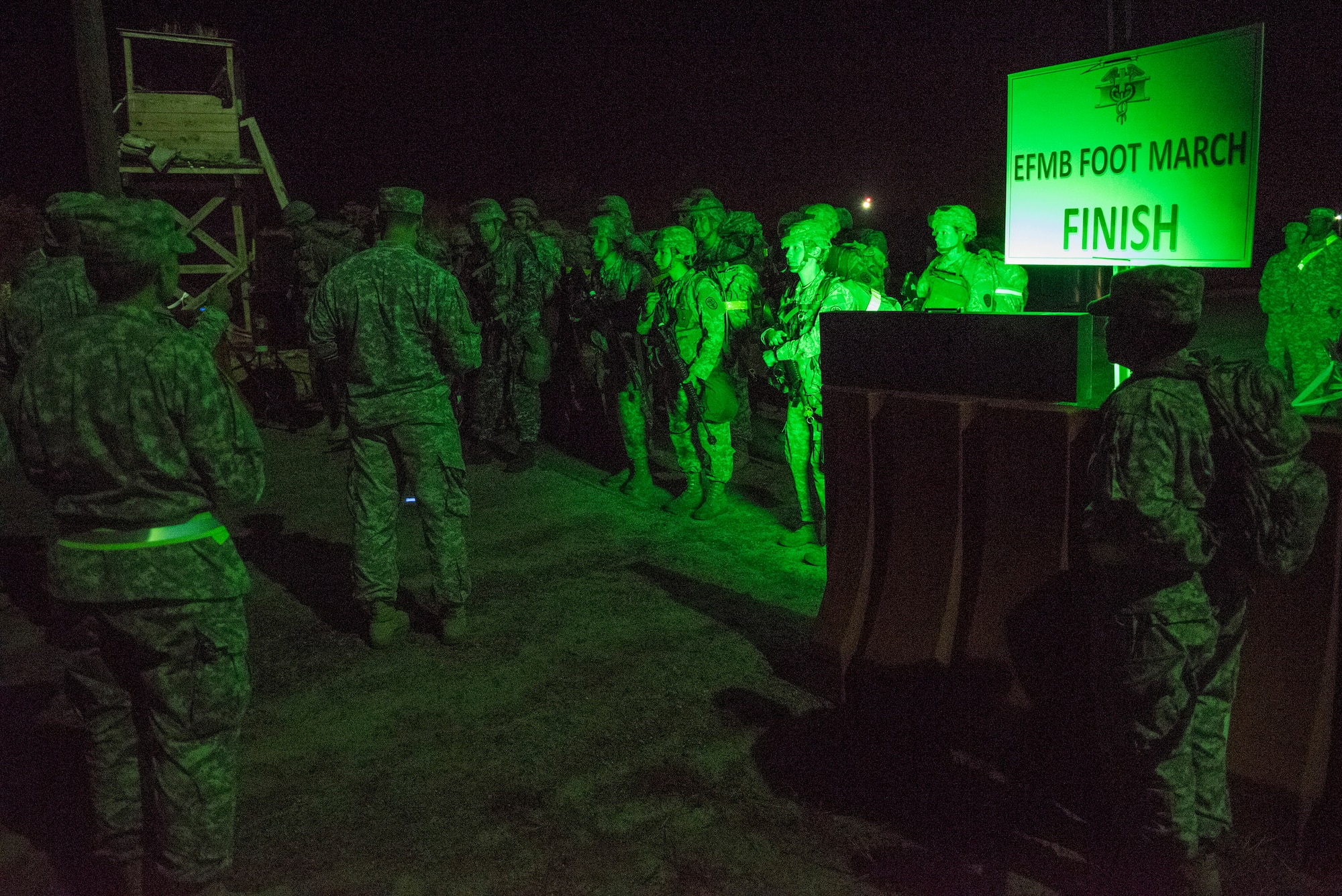 A group of 23 candidates line up as cadres countdown to the start of a 12-mile road march during an Expert Field Medical Badge competition at Joint Base McGuire-Dix-Lakehurst, N.J., Oct. 6, 2015. The road march was limited to three hours, while carrying nearly 40 pounds of equipment. Twenty one of the 23 finished the ruck to earn the coveted medical badge, including a Sailor and an Airman. (U.S. Air Force photo by Senior Airman Tara A. Williamson/Released)