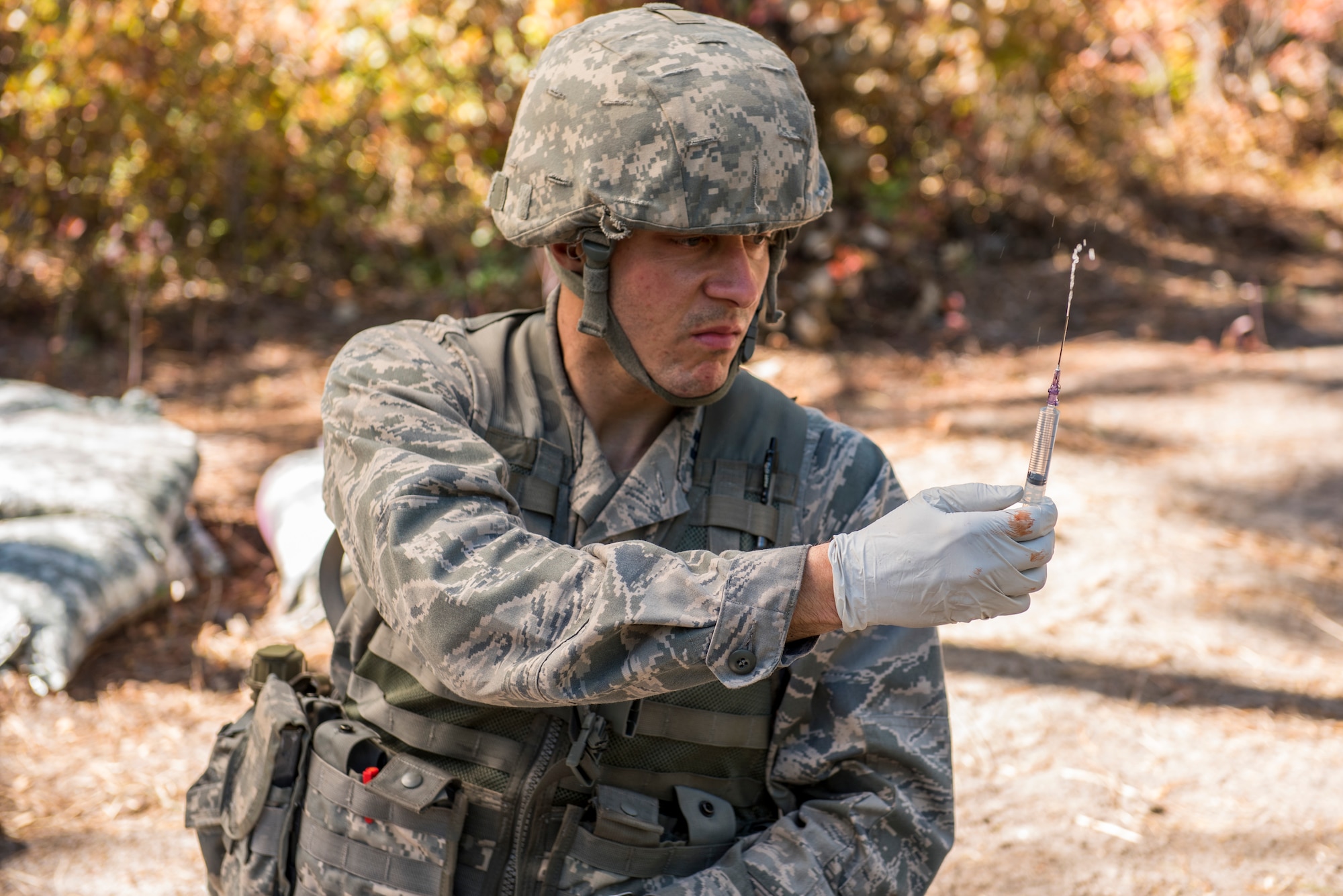 Capt. Richard Pate, Walter Reed National Military Medical Center nurse, prepares an injection for a simulated patient during an Expert Field Medical Badge competition at Joint Base McGuire-Dix-Lakehurst, N.J., Oct. 6, 2015. The EFMB candidates had to run through a tactical combat care course while evading simulated attacks and attending to patients. (U.S. Air Force photo by Senior Airman Tara A. Williamson/Released)
