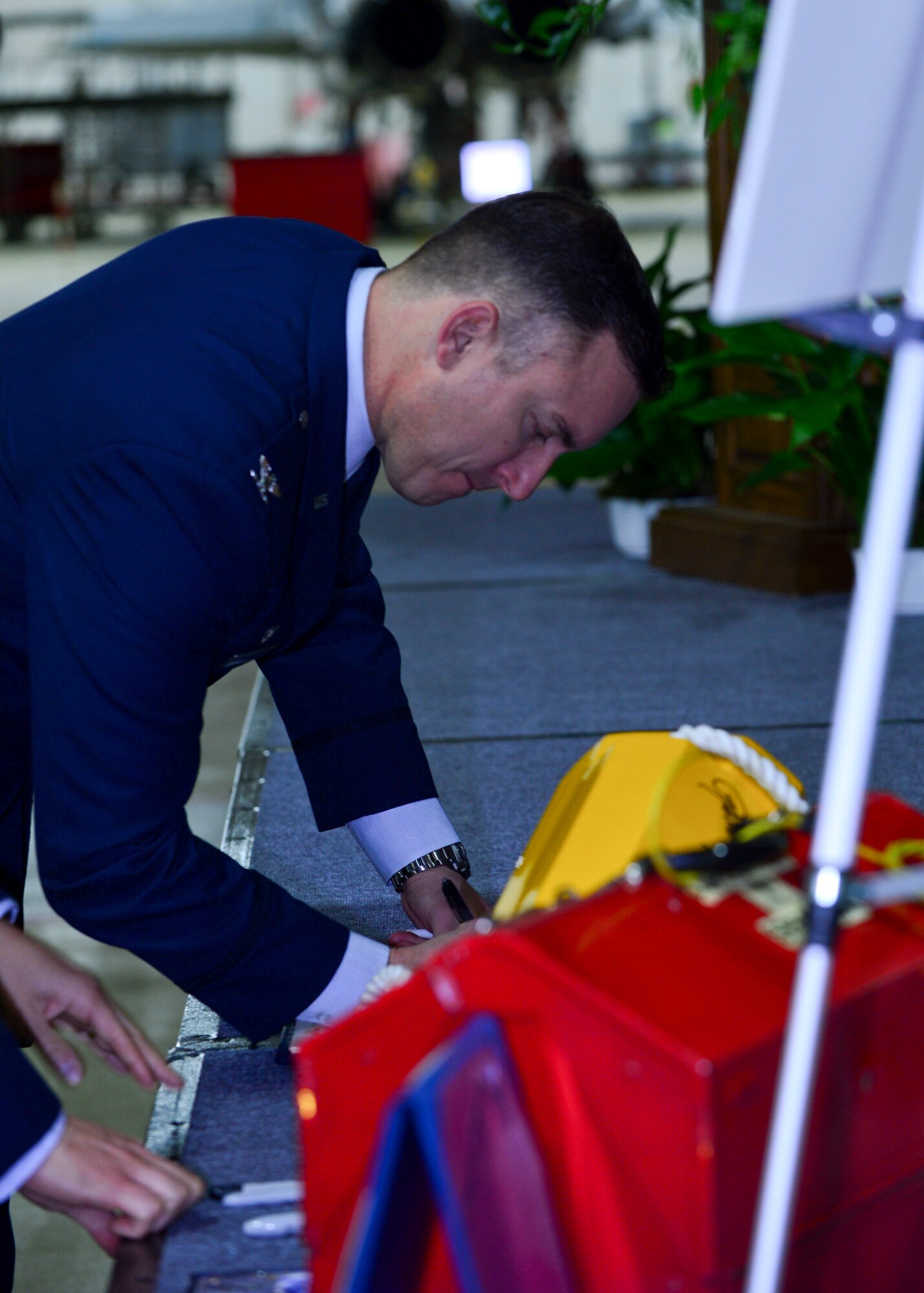 Col. Robert Novotny, 48th Fighter Wing commander, signs a guest book and wheel chock during a memorial ceremony for  Airman 1st Class Darren Phillips, 48th Equipment Maintenance Squadron crew chief, at Royal Air Force Lakenheath, England, Oct. 11, 2015. Phillips died from injuries sustained in a motorcycle accident on Oct. 2. (U.S. Air Force photo by Staff Sgt. Stephanie Longoria/Released)