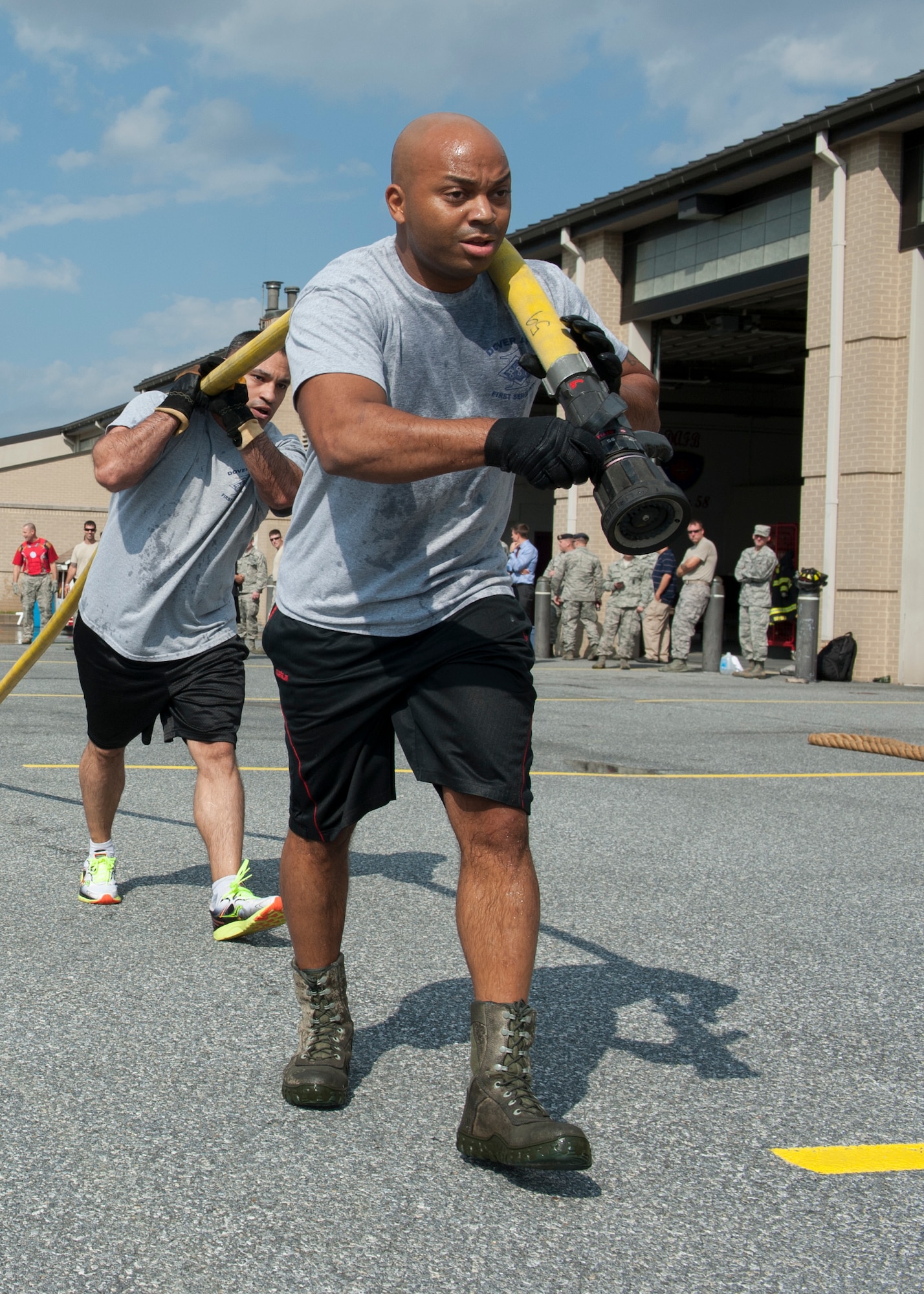 Master Sgt. Jamie Beard, 436th Security Forces Squadron first sergeant, and Master Sgt. William Garcia, 436th Aircraft Maintenance Squadron first sergeant, pull a firefighting attack line during the 2015 Fire Muster Oct. 8, 2015, at Dover Air Force Base, Del. Beard’s and Garcia’s team was comprised of Team Dover first sergeants. (U.S. Air Force photo/Senior Airman Zachary Cacicia)