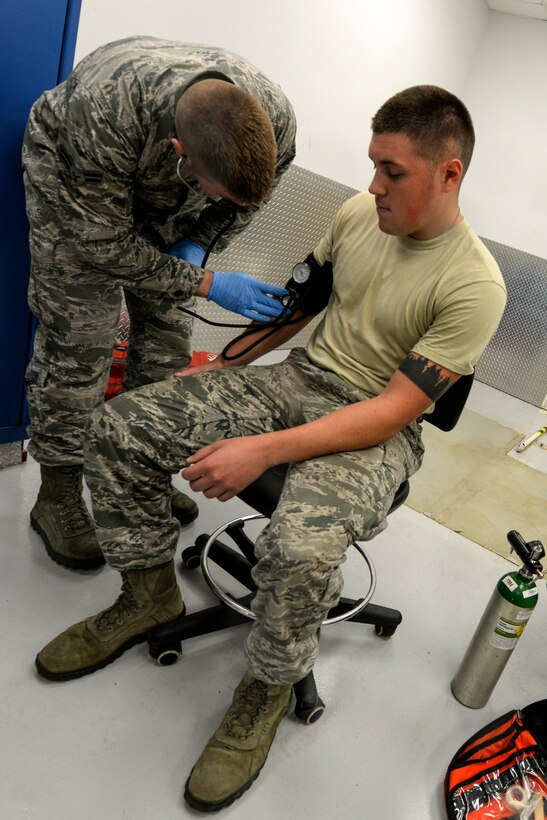 Airman 1st Class Troy Caillier (left), 4th Civil Engineer Squadron firefighter, practices taking blood pressure on Airman Tom Krasinski’s, 4th CES firefighter, Sept. 25, 2015, at Seymour Johnson Air Force Base, North Carolina. As first responders, firefighters are trained to react to medical emergencies as it’s possible they will have first contact with a victim. (U.S. Air Force photo/ Airman 1st Class Ashley Williamson)