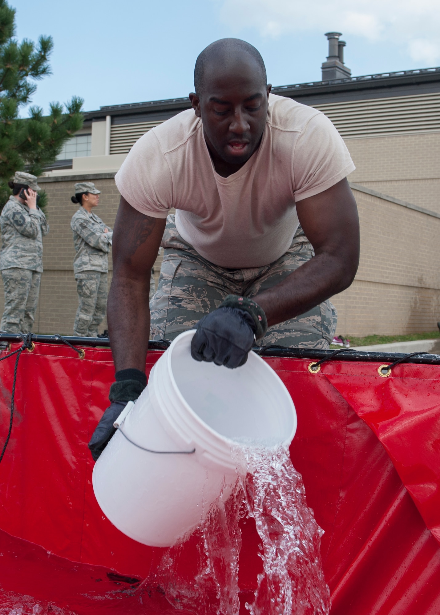 Staff Sgt. Damien Sawyer, 436th Security Forces Squadron NCO in charge of resource protection, scoops a bucket full of water during the 2015 Fire Muster Oct. 8, 2015, at Dover Air Force Base, Del. Nine teams comprised of four members each took part in the event. (U.S. Air Force photo/Senior Airman Zachary Cacicia)
