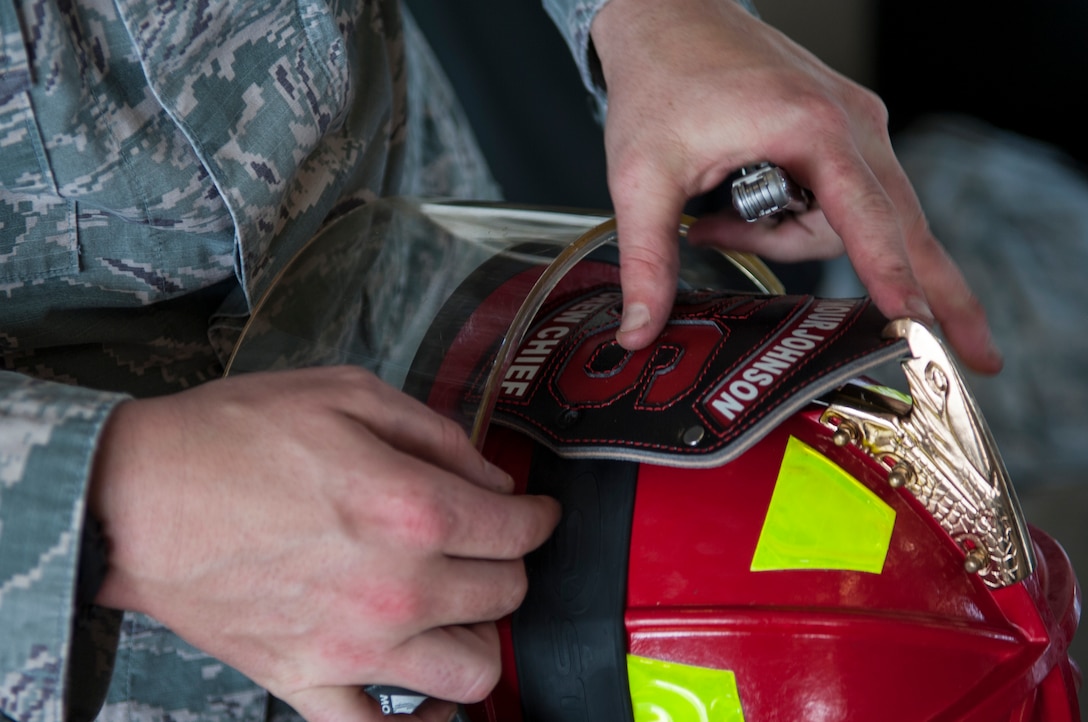 Staff Sgt. Justin Fellure, 4th Civil Engineer Squadron fire department crew chief, reattaches a numbered shield to the front of a helmet, Sept. 17, 2015, at Seymour Johnson Air Force Base, North Carolina. All firefighters have numbers assigned to them to help identify them while in their gear. (U.S. Air Force photo/Airman Shawna L. Keyes)