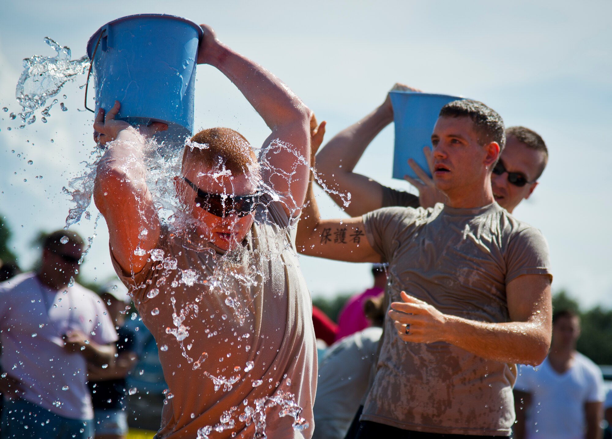 A participant gets splashed as he passes back a holy bucket of water during the Fire Muster Challenge Oct. 9 at Eglin Air Force Base, Fla.  Teams competed in the timed challenge that included shooting and rolling up the fire hose, hammer sled, victim-carry and water relay. The challenge closed out the base’s Fire Prevention Week activities.  (U.S. Air Force photo/Samuel King Jr.)