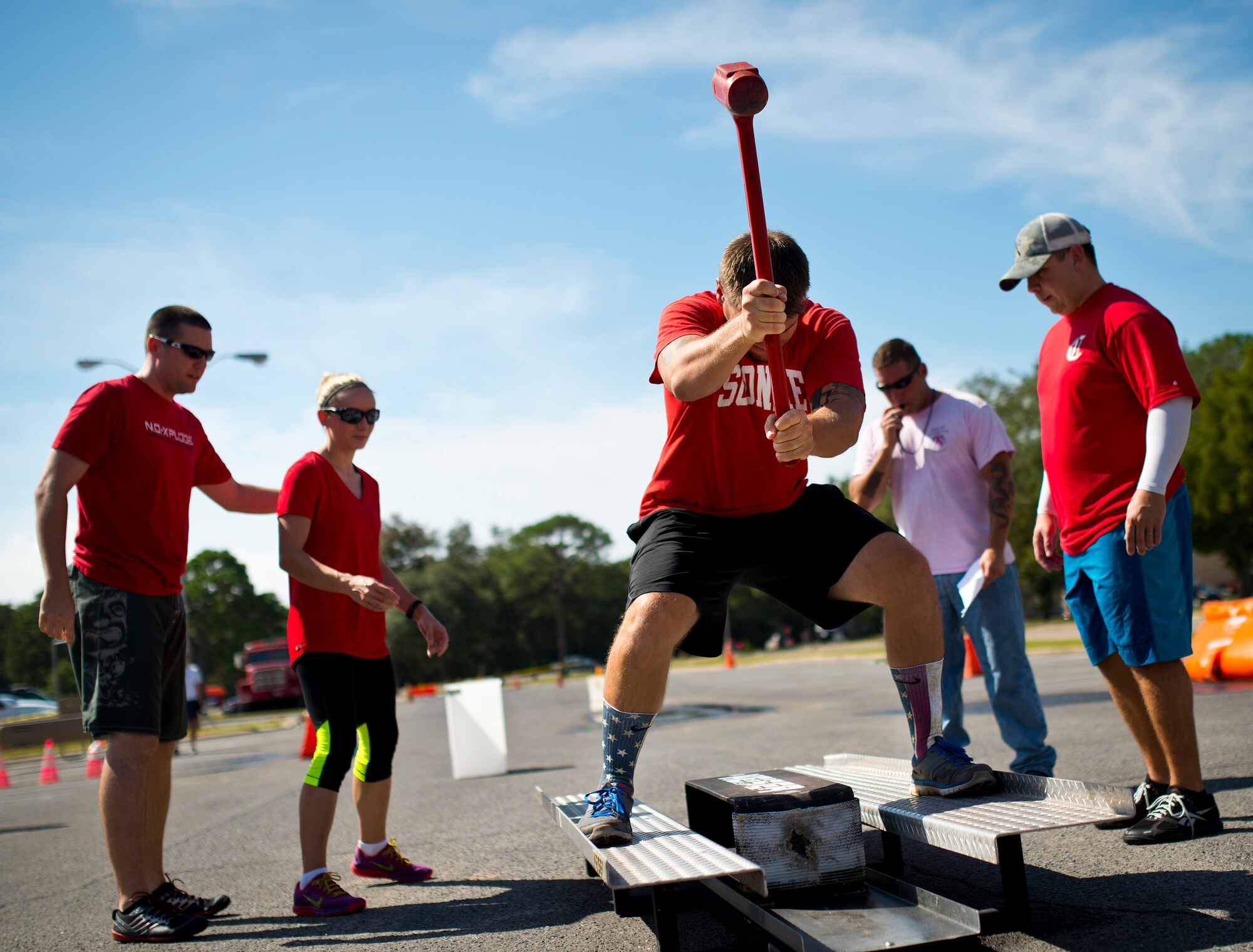 A team begins the fire hose roll out and roll up portion of the Fire Muster Challenge Oct. 9 at Eglin Air Force Base, Fla.  Teams competed in the timed challenge that included shooting and rolling up the fire hose, hammer sled, victim-carry and water relay. The challenge closed out the base’s Fire Prevention Week activities.  (U.S. Air Force photo/Samuel King Jr.)