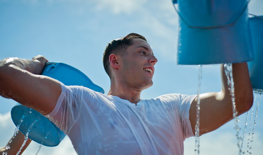 A participant passes back a holy bucket of water during the Fire Muster Challenge Oct. 9 at Eglin Air Force Base, Fla.  Teams competed in the timed challenge that included shooting and rolling up the fire hose, hammer sled, victim-carry and water relay. The challenge closed out the base’s Fire Prevention Week activities.  (U.S. Air Force photo/Samuel King Jr.)
