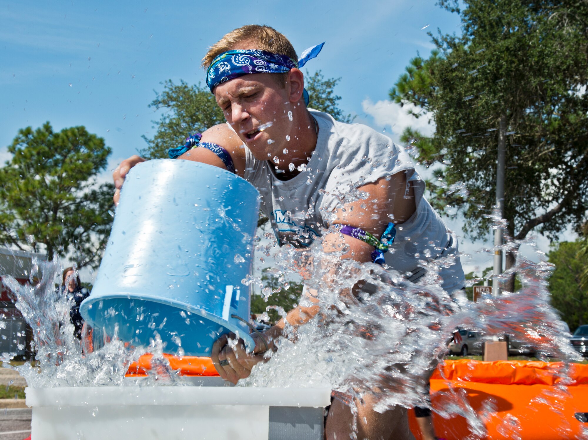 A participant dumps water into a container at the end of the water relay portion of the Fire Muster Challenge Oct. 9 at Eglin Air Force Base, Fla.  Teams competed in the timed challenge that included shooting and rolling up the fire hose, hammer sled, victim-carry and water relay. The challenge closed out the base’s Fire Prevention Week activities.  (U.S. Air Force photo/Samuel King Jr.)
