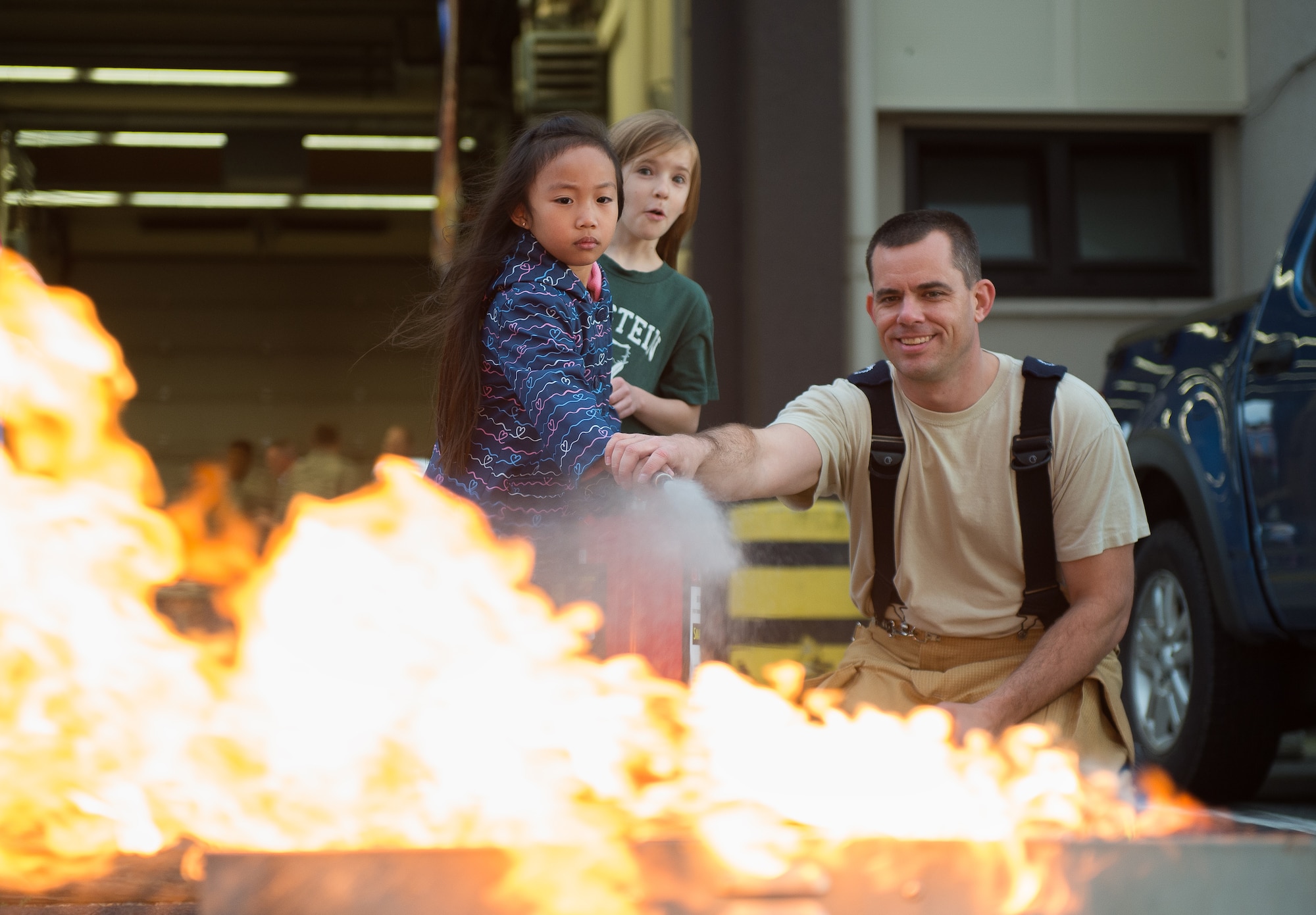 Master Sgt. Mark Goenen, 86th Civil Engineer Squadron Kaiserslautern Military Community fire emergency services, shows children how to properly use a fire extinguisher Oct. 8, 2015, at Ramstein Air Base, Germany. As part of Fire Prevention Week, families visited Fire Station 1 to learn about fire safety including home-fire safety issues, fire extinguisher training and holiday safety tips. (U.S. Air Force photo/Senior Airman Damon Kasberg)