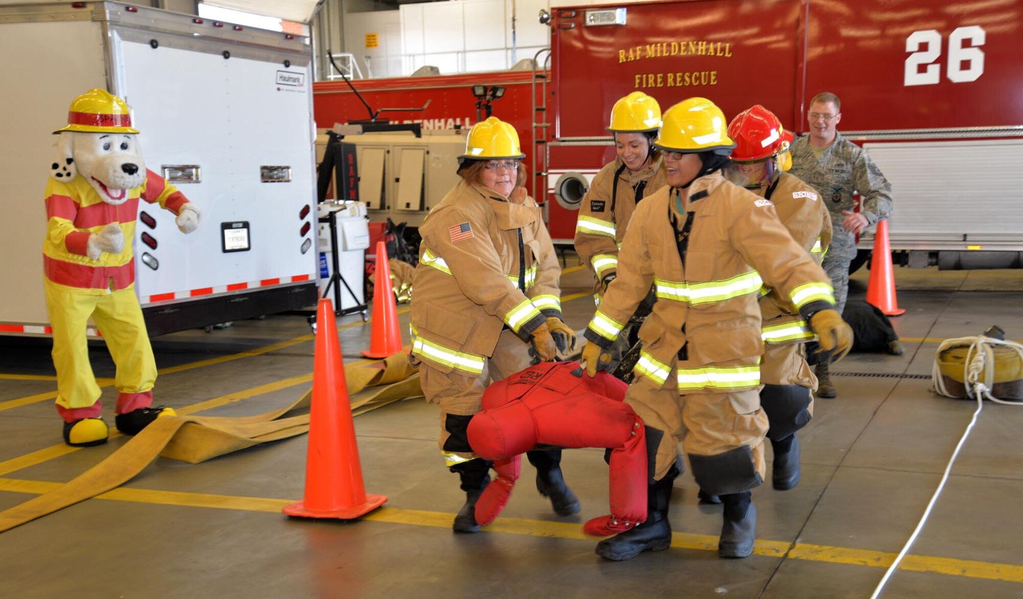 Members of “The HAKA” team, 100th Civil Engineer Squadron, carry a mannequin as they race to the next station of the fire muster, for Fire Prevention Week Oct. 8, 2015, on RAF Mildenhall. Teams from squadrons including 100th CES and the 100th Logistics Readiness Squadron, along with the Chiefs and Eagles, participated in the event, which included a hose pull, dry hose advancement, mannequin rescue and Keiser sled. (U.S. Air Force photo by Karen Abeyasekere/Released)