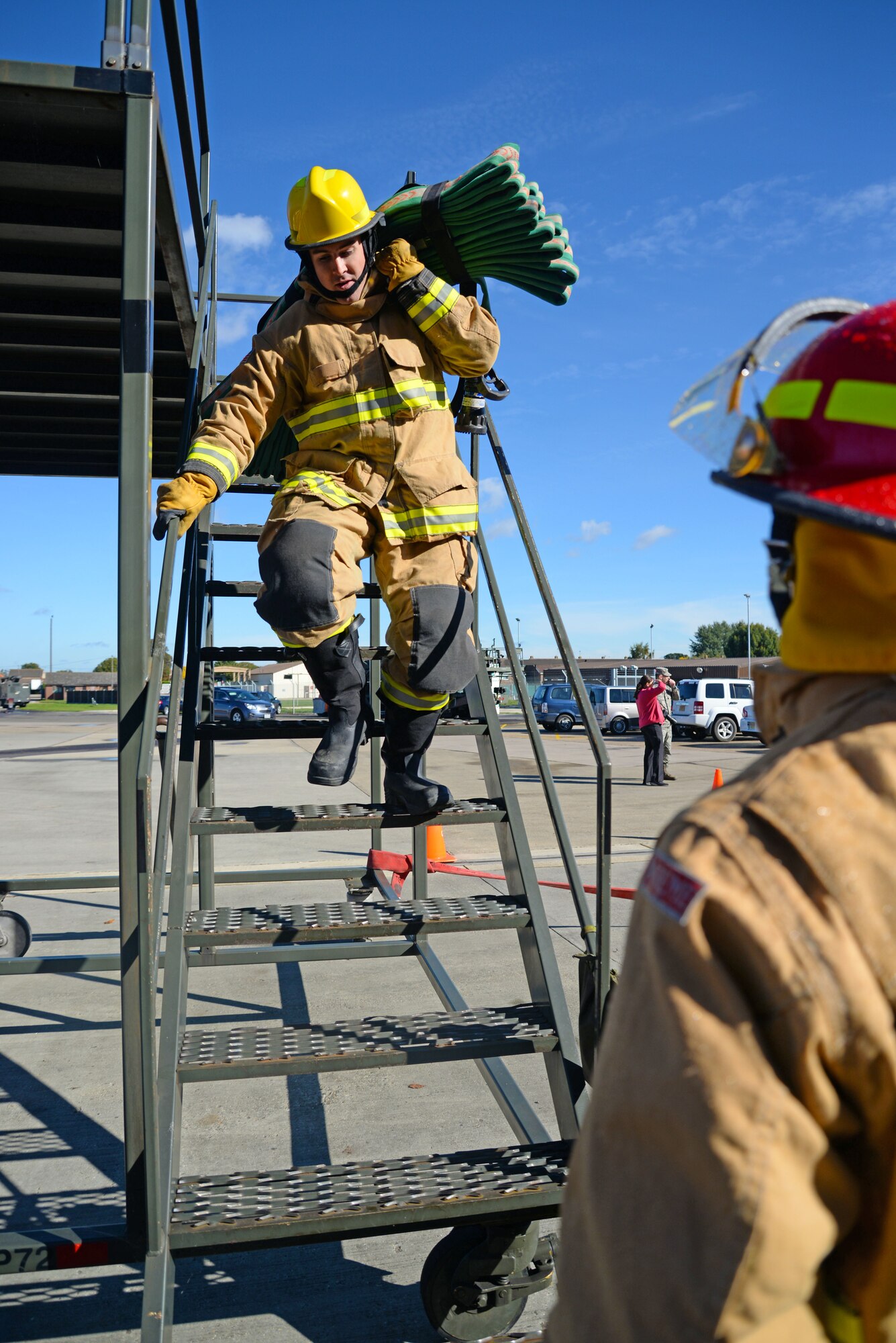 U.S. Air Force Staff Sgt. Jacob Hoar, 100th Civil Engineer Squadron electrical craftsman, carries a hose down a set of stairs during a fire muster competition at the 100th Civil Engineer Squadron fire department Oct. 8, 2015, on RAF Mildenhall, England. The fire muster was part of Fire Prevention Week events where 10 teams competed in the challenge, which consisted of a bunker drill, hose pull, mannequin carry, hose connection and bucket brigade station.  (U.S. Air Force photo by Senior Airman Christine Halan/Released)