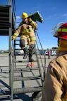 U.S. Air Force Staff Sgt. Jacob Hoar, 100th Civil Engineer Squadron electrical craftsman, carries a hose down a set of stairs during a fire muster competition at the 100th Civil Engineer Squadron fire department Oct. 8, 2015, on RAF Mildenhall, England. The fire muster was part of Fire Prevention Week events where 10 teams competed in the challenge, which consisted of a bunker drill, hose pull, mannequin carry, hose connection and bucket brigade station.  (U.S. Air Force photo by Senior Airman Christine Halan/Released)