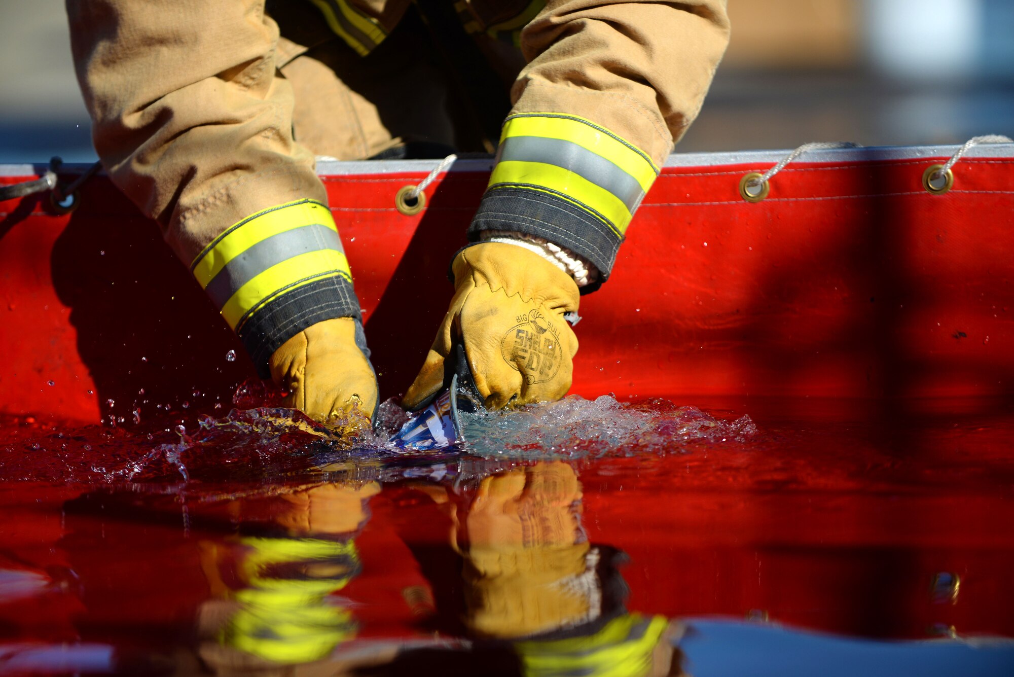 A U.S. Air Force Airman from the 100th Logistics Readiness Squadron collects water in a bucket during a fire muster competition at the 100th Civil Engineer Squadron fire department Oct. 8, 2015, on RAF Mildenhall, England. The fire muster was one of many events held during Fire Prevention Week. (U.S. Air Force photo by Senior Airman Christine Halan/Released)