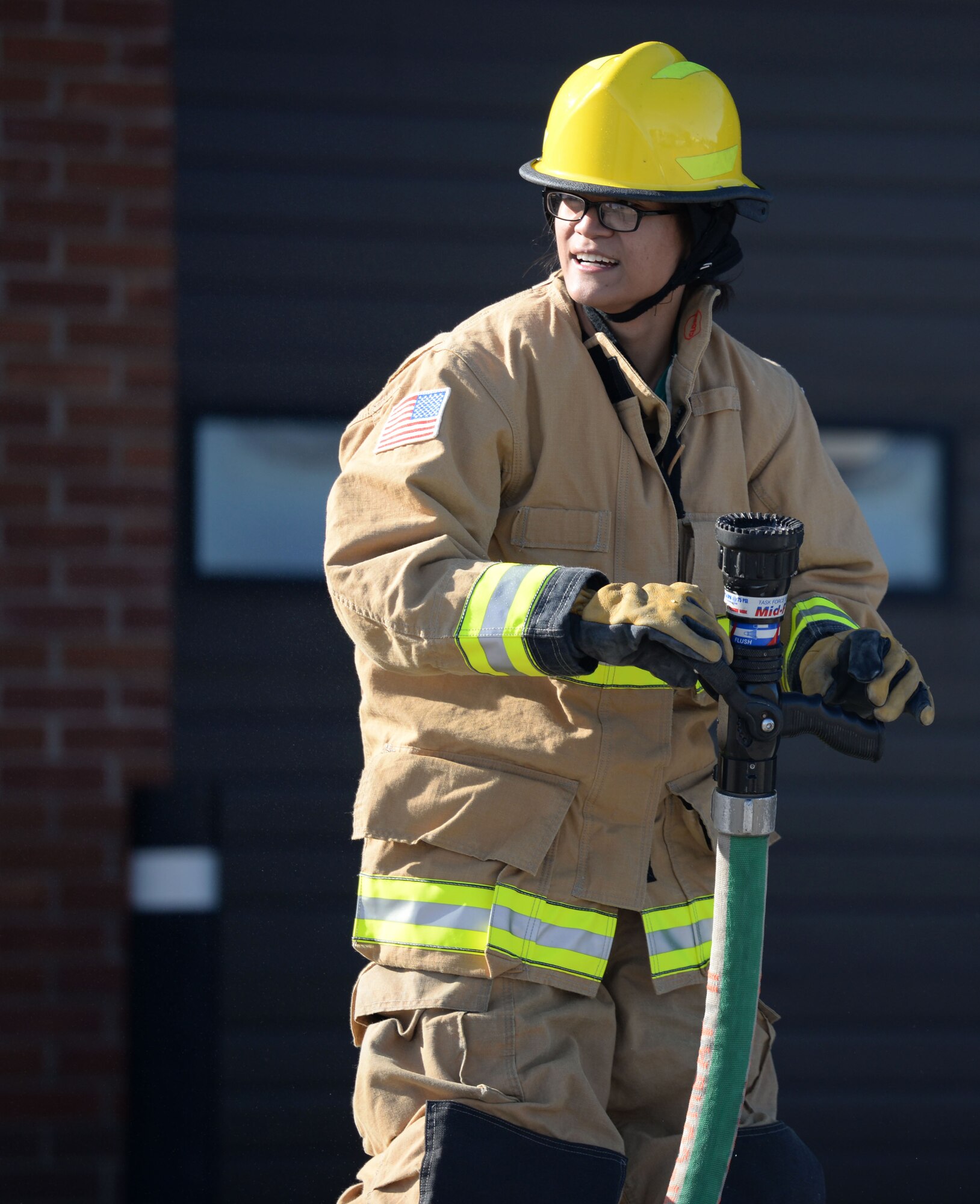 U.S. Air Force Senior Airman Abigail Slater, 100th Civil Engineer Squadron engineer journeyman, takes part in the fire muster competition Oct. 8, 2015, on RAF Mildenhall, England. The fastest team through the firefighter related challenges won a prize as part of fire prevention week events. (U.S. Air Force photo by Gina Randall/Released)