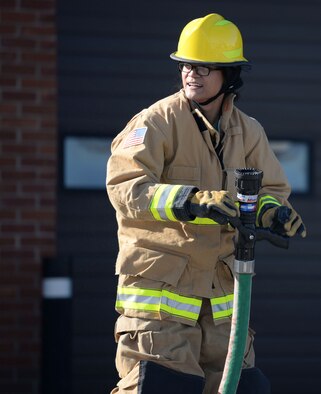 U.S. Air Force Senior Airman Abigail Slater, 100th Civil Engineer Squadron engineer journeyman, takes part in the fire muster competition Oct. 8, 2015, on RAF Mildenhall, England. The fastest team through the firefighter related challenges won a prize as part of fire prevention week events. (U.S. Air Force photo by Gina Randall/Released)