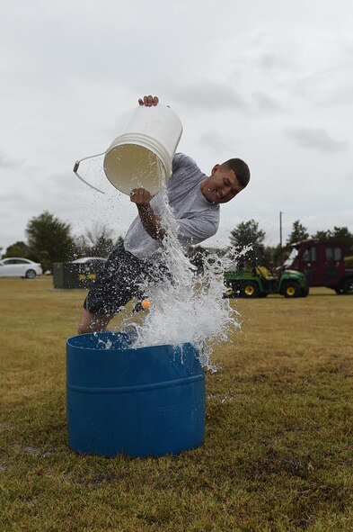 ALTUS AIR FORCE BASE, Okla. – U.S. Air Force Airman 1st Class Brandon Giambelluca, 97th Logistics Readiness Squadron vehicle maintenance apprentice, slams water into a 25-gallon bucket to knock a ping-pong ball out during a water-bucket race at the Annual Firefighter Muster, Oct. 9 at the Wings of Freedom Park. This year’s muster was comprised of 15 teams competing in seven timed events for lowest cumulative time. (U.S. Air Force photo by Senior Airman Dillon Davis/Released)