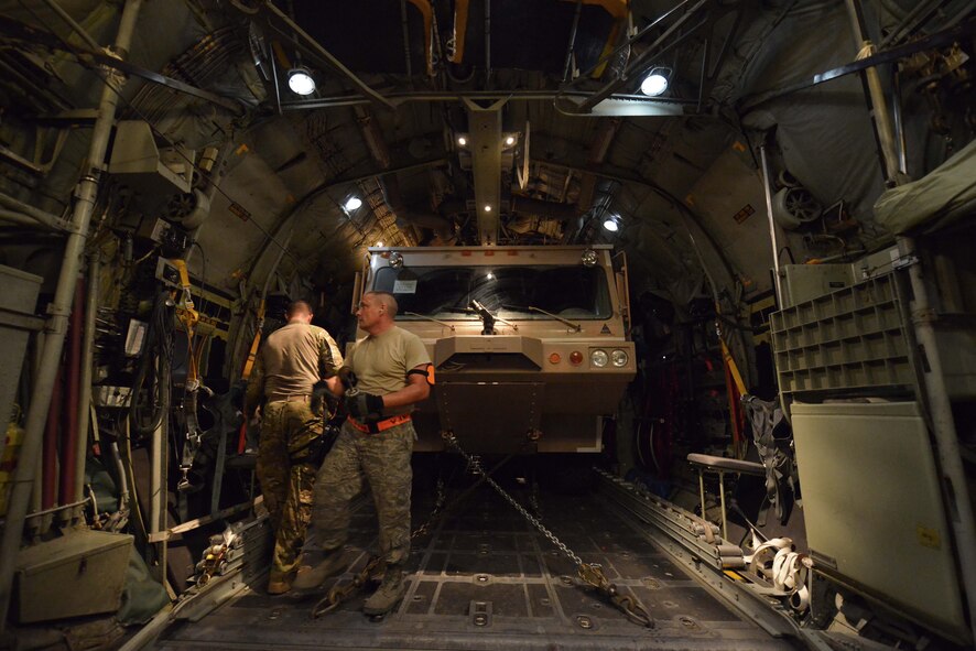 Aircrew of the 746th Expeditionary Airlift Squadron and aerial porters from the 8th Expeditionary Air Mobility Squadron complete final safety checks of a P-19 Aircraft Rescue Fire Fighting vehicle tie-down inside a C-130J Hercules prior to closing the cargo door   October 12, 2015 at Al Udeid Air Base, Qatar. Aircrew from the 746th EAS received help from Airmen of the 8th EAMS to load the P-19 ARFF vehicle that will be used at a Forward Operating Base. (U.S. Air Force photo/Staff Sgt. Alexandre Montes)
