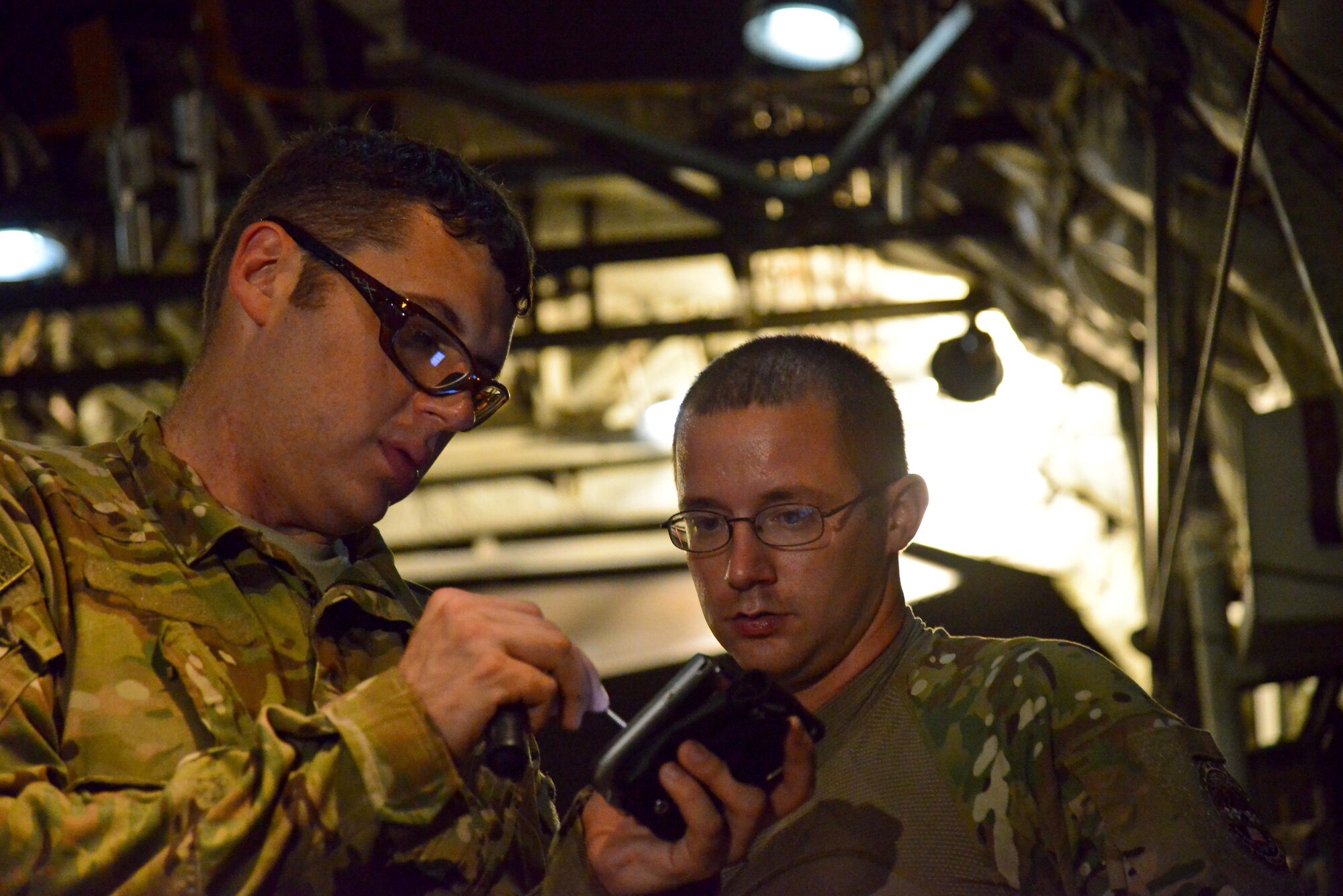 Staff Sgt. Ricky Davis and Tech Sgt. Wyatt Lewis, 746th Expeditionary Airlift Squadron crew chiefs, complete final calculations prior to loading a 23,000 pound P-19 Aircraft Rescue Fire Fighting vehicle onto a C-130J Hercules October 12, 2015 at Al Udeid Air Base, Qatar. Aircrew from the 746th EAS received help from Airmen of the 8th Expeditionary Air Mobility Squadron to load the P-19 ARFF vehicle that will be used at a Forward Operating Base. (U.S. Air Force photo/Staff Sgt. Alexandre Montes)