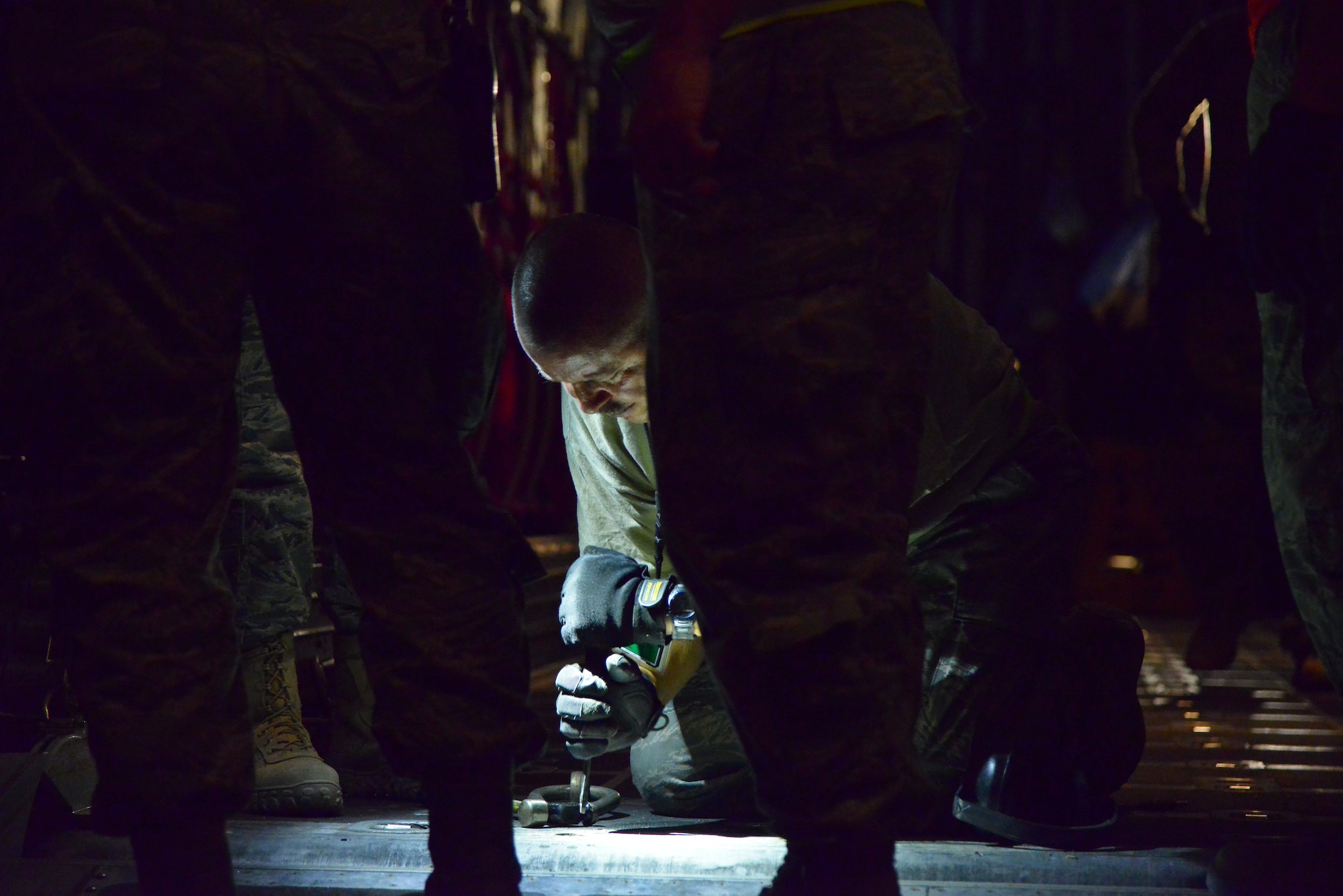 Chief MSgt. James Rickels, 746th Expeditionary Airlift Squadron, exchanges tie-down locks prior to loading a 23,000 pound P-19 Aircraft Rescue Fire Fighting vehicle onto a C-130J Hercules October 12, 2015 at Al Udeid Air Base, Qatar. Aircrew from the 746th EAS received help from Airmen of the 8th Expeditionary Air Mobility Squadron to load the P-19 ARFF vehicle that will be used at a Forward Operating Base. (U.S. Air Force photo/Staff Sgt. Alexandre Montes)