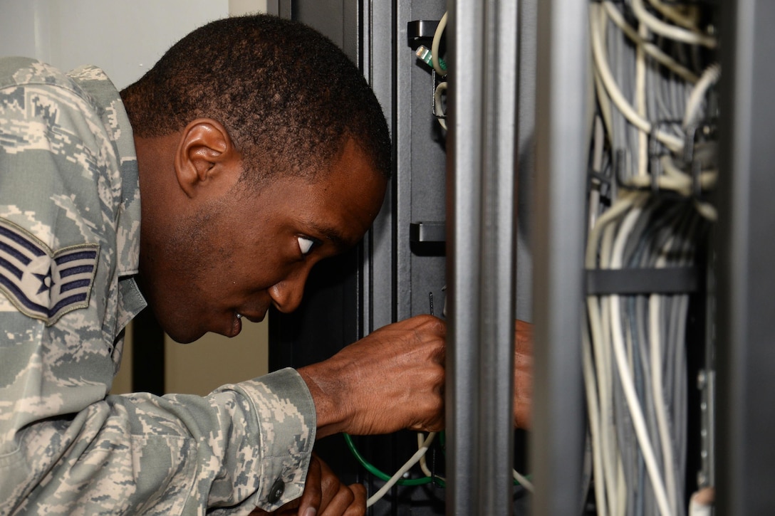 U.S. Air Force Staff Sgt. Christerfer James runs cable on RAF Mildenhall, England, Sept. 4, 2015. James, 100th Communication Squadron Cyber Transport supervisor, was granting RAF Mildenhall users the ability to access the base nonsecure internet protocol router and secure internet protocol router network. (U.S. Air Force photo by Gina Randall/Released)