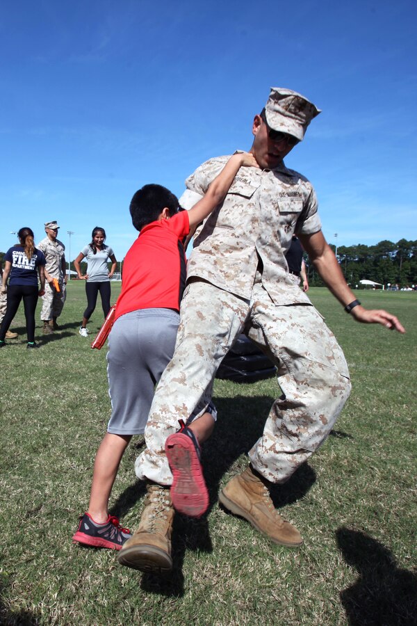 Diego, 8, left, performs a leg sweep on Capt. Agustin Arreola during the second annual Jayne and John Wayne Day hosted by Marine Aviation Logistics Squadron 14 at Marine Corps Air Station Cherry Point, N.C., Oct. 9, 2015. Family members toured their service member’s workspaces, participate in a portion of the Marines’ Combat Fitness Test and turned a few wrenches all to build relationships with the command, meet other families and build camaraderie with the unit. MALS-14 provides aviation logistics support, guidance, and direction to Marine Aircraft Group 14 squadrons including maintenance for aircraft and aeronautical components. Arreola is the operations officer with the squadron.