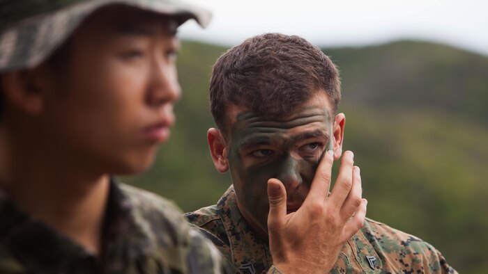U.S. Marine Corps Cpl. Josh J. Neahusan, right, applies camouflage paint during a sniper training exchange exercise between Marines of the Republic of Korea and the U.S. at Baengnyeongdo, Republic of Korea, Sept. 11, 2015. Marines from both countries exchanged weapon systems, methods of concealment, and capabilities throughout the training. The exercise was part of Korean Marine Exchange Program 15-13, a bilateral training exercise that enhances the ROK and U.S. alliance, promotes stability on the Korean Peninsula, and strengthens ROK and U.S. military capabilities. Neahusan, from Middletown, Maryland, is a scout sniper attached to Echo Company, 2nd Battalion, 3rd Marine Regiment, currently assigned to 4th Marine Regiment, 3rd Marine Division, III Marine Expeditionary Force, under the unit deployment program. The ROK Marines are with 6th Force Recon Company, 6th Brigade, 2nd ROK Marine Corps Division. 