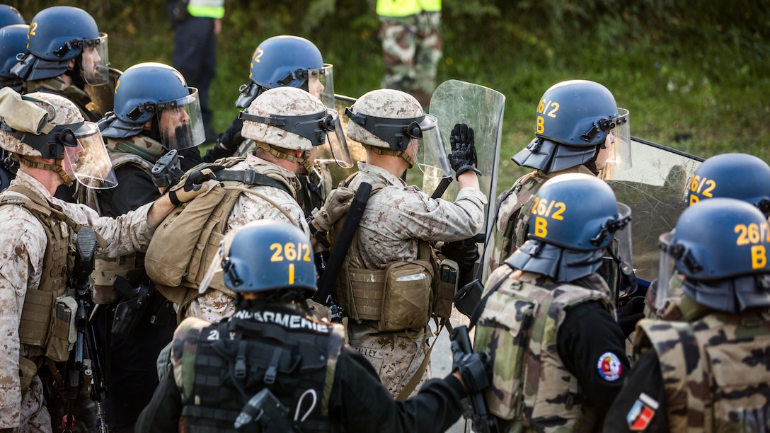 U.S. Marines stand alongside French Gendarmes during riot control exercise at the National Gendarmerie Tactical Training Center in Saint-Astier, France, Oct. 9. During the exercise, a platoon of Marines was put to the test, dealing with tear gas, Molotov cocktails and a large group of angry protesters. 