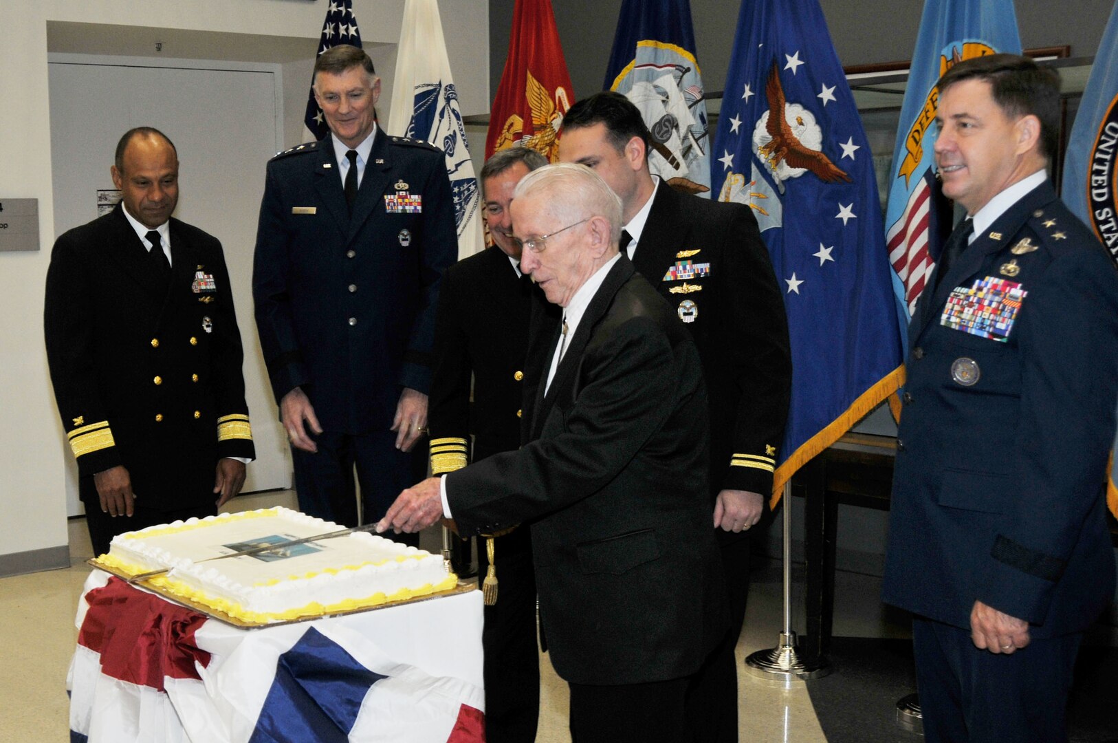 A Navy birthday cake is cut by senior leaders and the oldest and youngest sailors present during a celebration of the service’s 240th birthday at the McNamara Headquarters Complex Oct. 13.